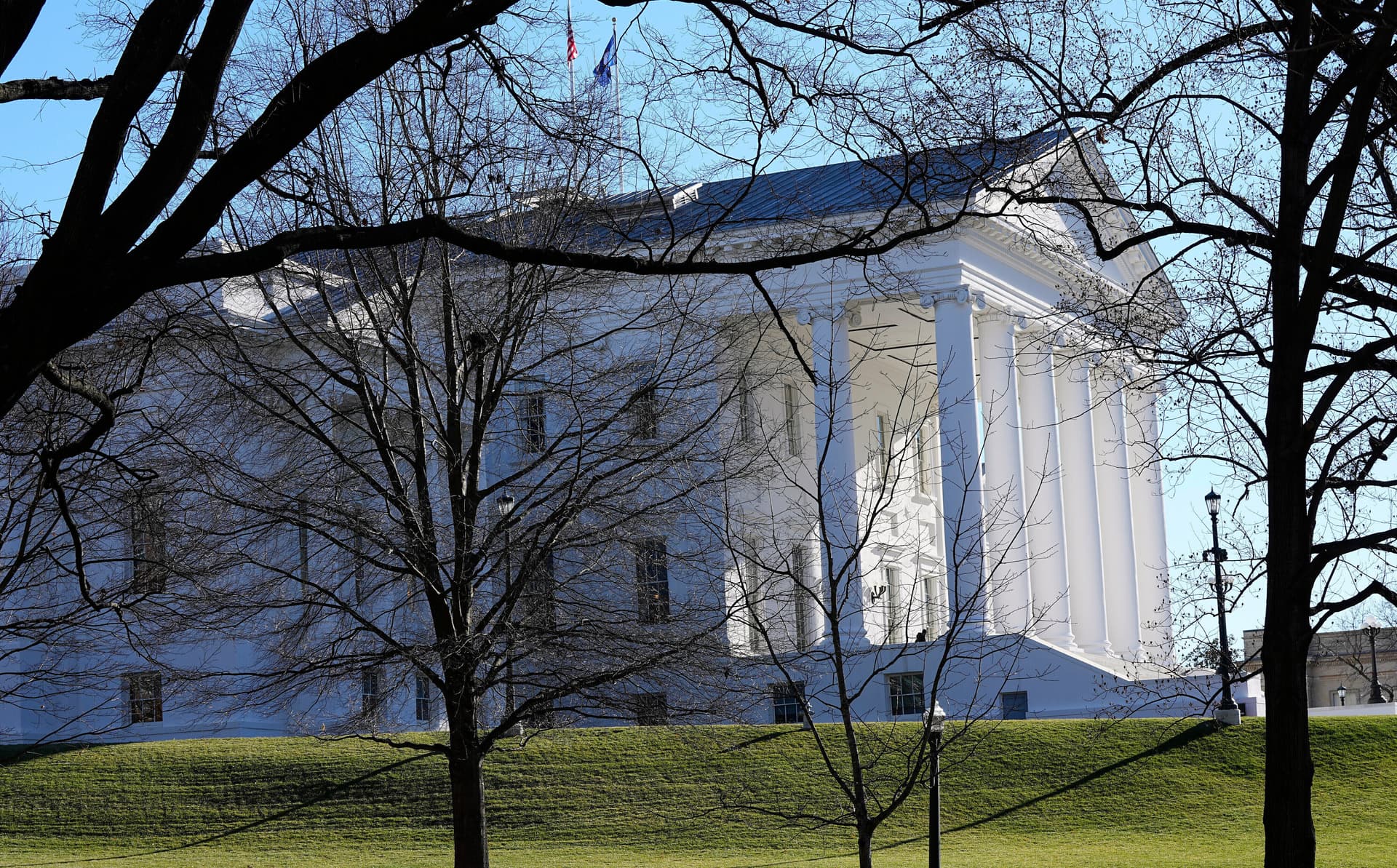 Steve Helber/AP The state and U.S. flags fly over the Virginia State Capitol at Richmond on January 10, 2024.