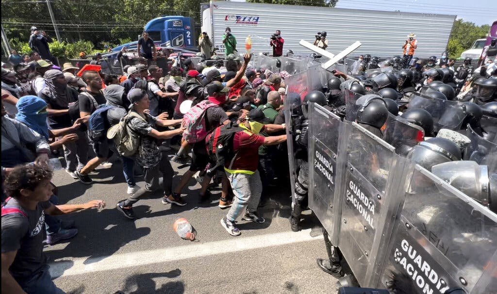Migrants break through a line of National Guards at Tapachula, Mexico, Friday, April 1, 2022. AP Photo/Edgar H. Clemente