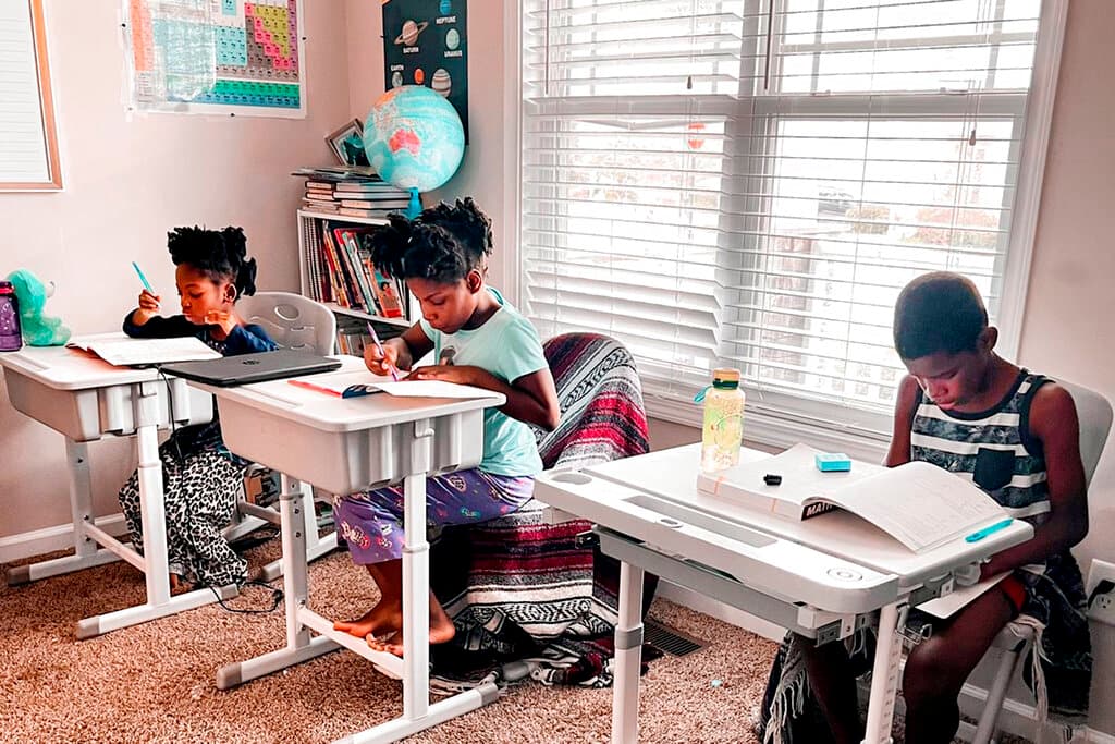 Drew Waller, 7, Zion Waller, 10, and Ahmad Waller, 11, left to right, study during homeschooling, at Raleigh, North Carolina. 