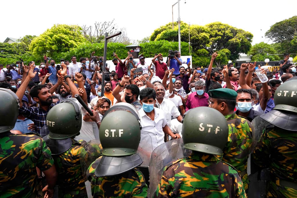 Sri Lankan government supporters cheer after vandalizing the site of anti-government protest outside prime minister's residence at Colombo, May 9, 2022.  AP/Eranga Jayawardena