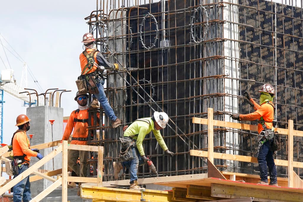 Construction laborers fasten the frame of a new building, May 3, 2021, at Miami. 