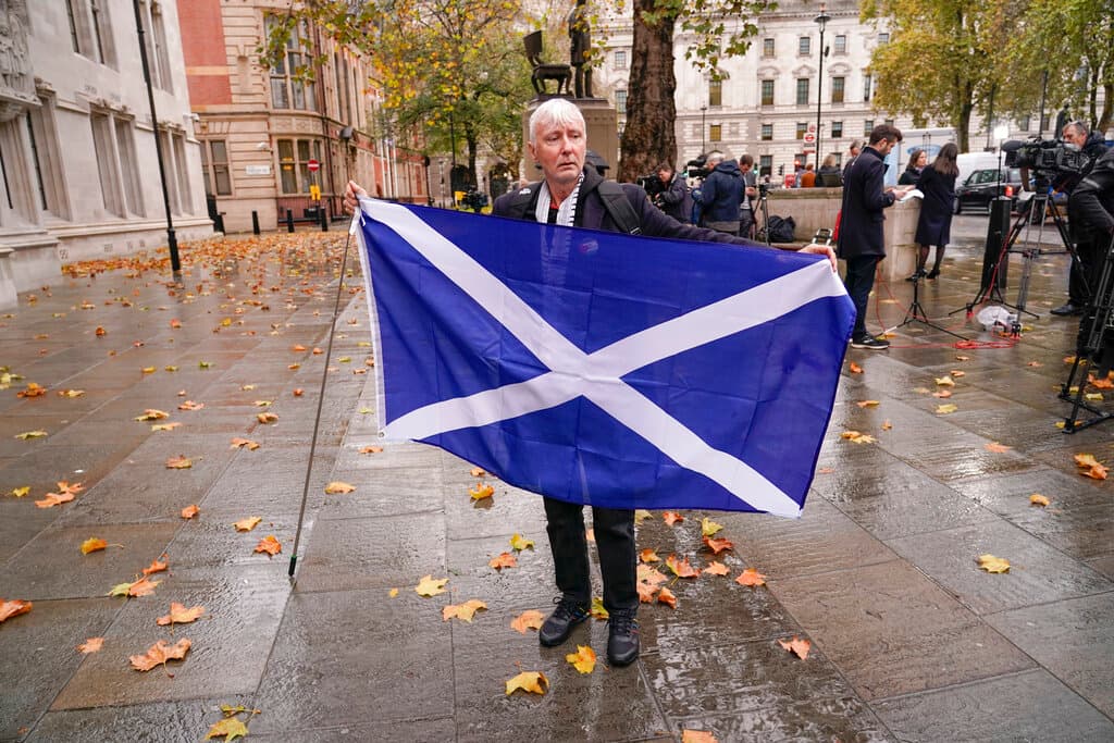 A demonstrator holds a Scottish flag outside the Supreme Court at London, November 23, 2022. 