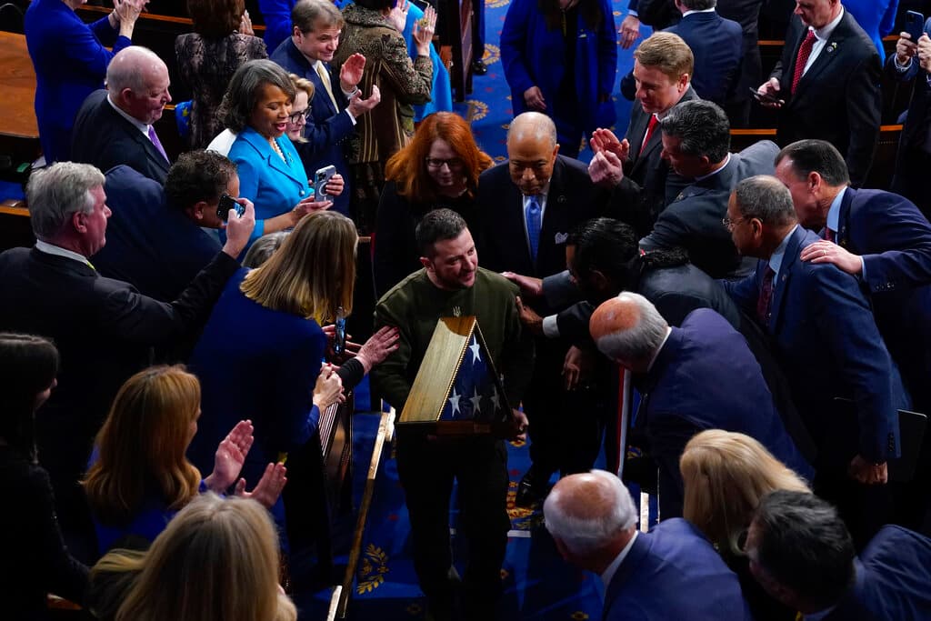 The Ukrainian president, Volodymyr Zelensky, holds an American flag as he leaves after addressing a joint meeting of Congress December 21, 2022. 