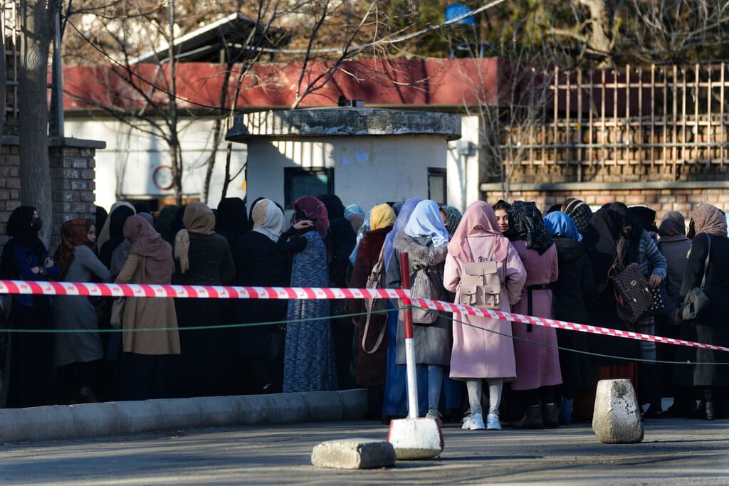 Afghan students queue at one of Kabul University's gates at, Afghanistan, on February 26, 2022. 