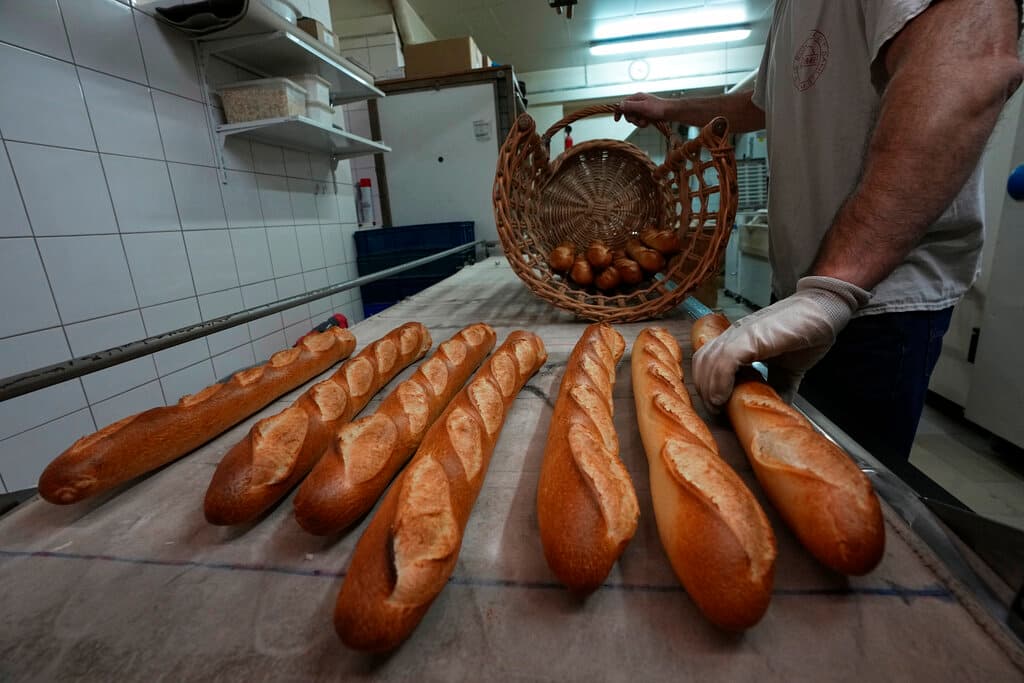 Baguettes are put into a basket at a bakery at Versailles November 29, 2022. 