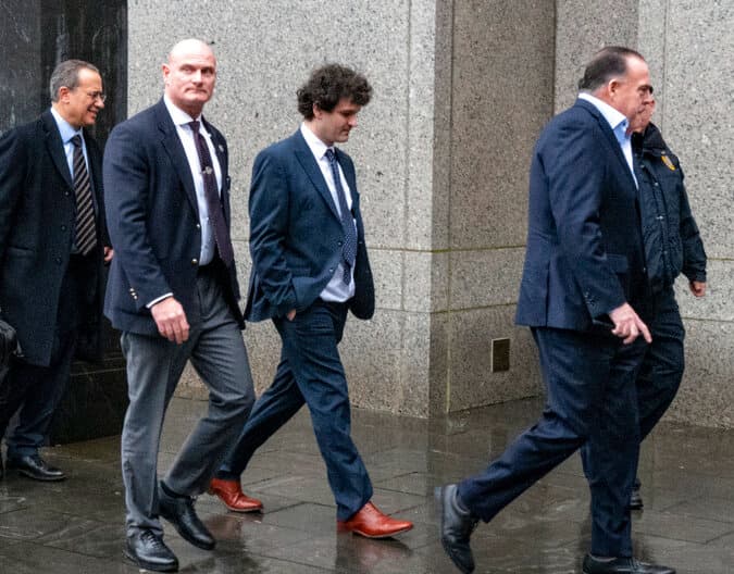 Cryptocurrency entrepreneur Sam Bankman-Fried, second from right, arrives at Manhattan federal court January 3, 2023. 