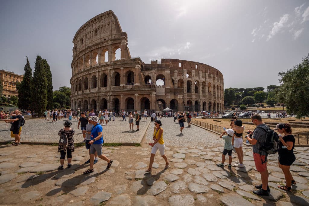 People refresh themselves outside the Colosseum amid high temperatures at Rome, on August 10, 2021. 