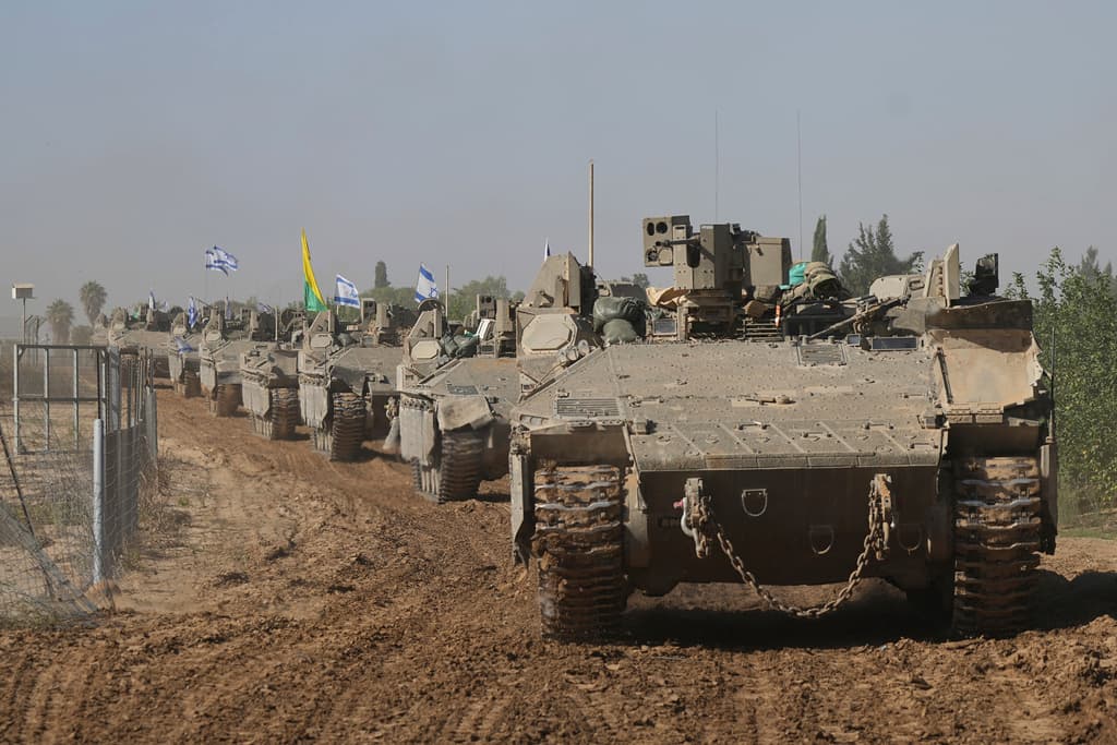 A convoy of Israeli army vehicles maneuvers near Israel's border after leaving Gaza, southern Israel, November 24, 2023.
