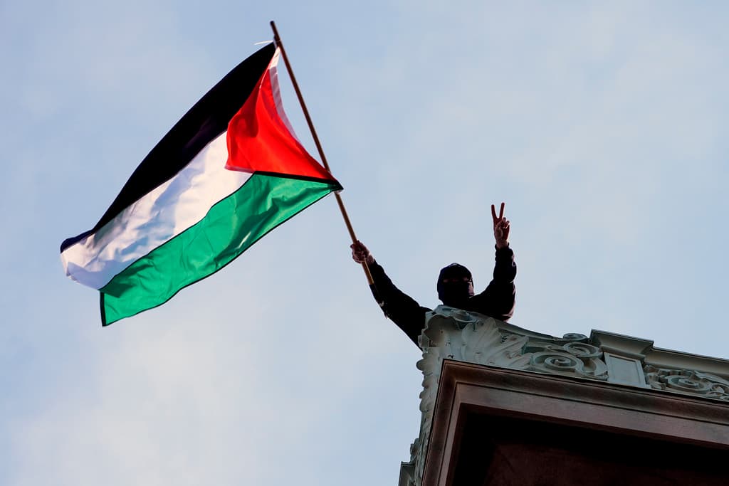A student protester waves a Palestinian flag above Hamilton Hall on the campus of Columbia University, Tuesday, April 30, 2024, at New York. 