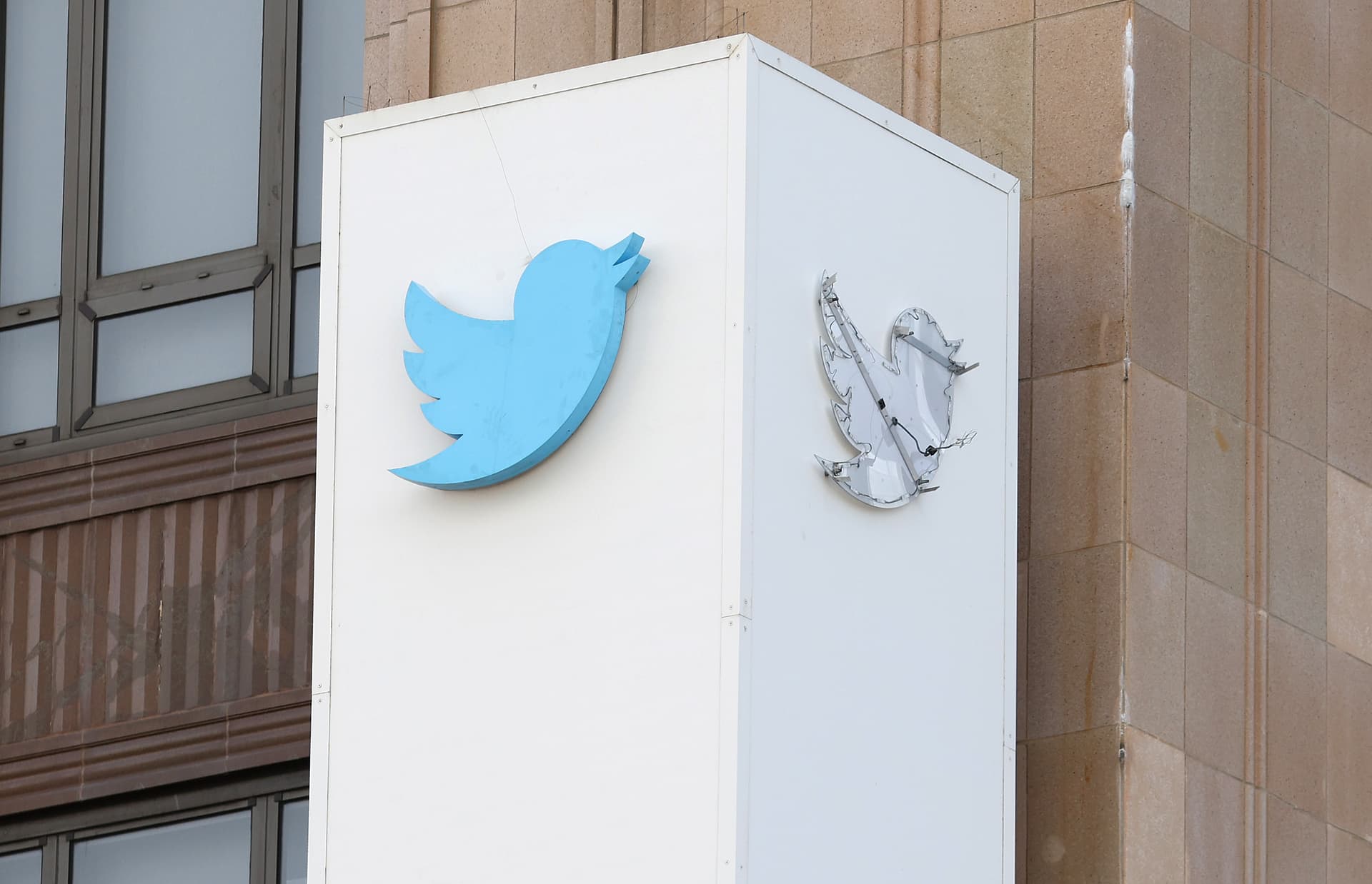 The outline of the iconic blue Twitter bird logo is visible on a sign in front of X headquarters in San Francisco, California.