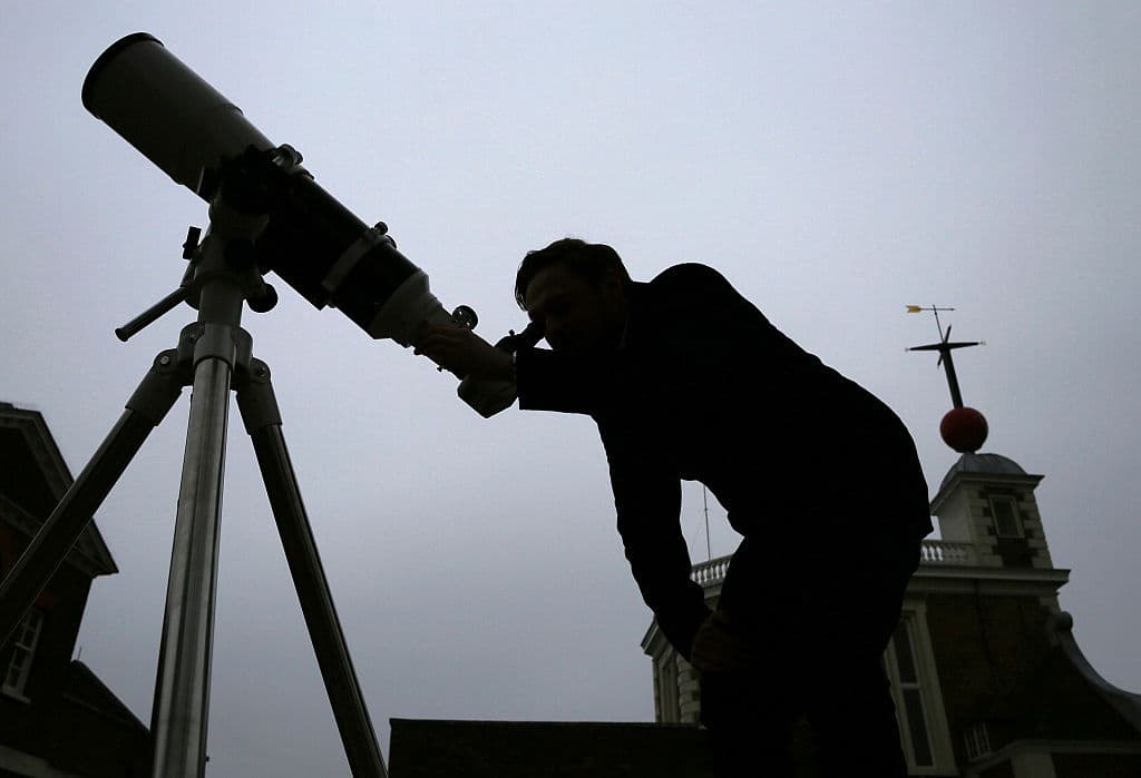 Astronomer Brendan Owens with a 6 inch refractor telescope at the Royal Observatory at Greenwich, England.