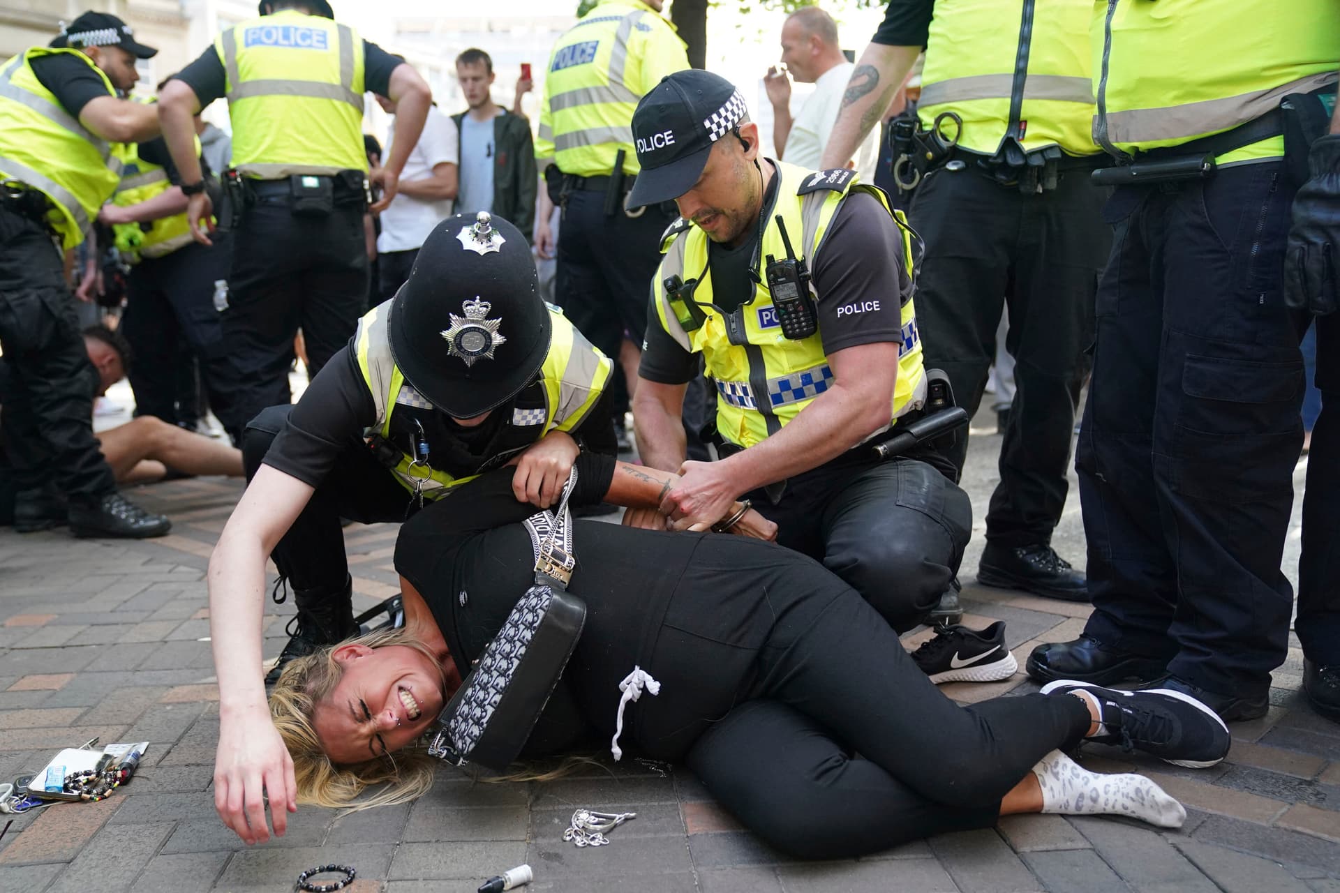 Police officers detain a woman during a protest at Nottingham, England, August 2024.