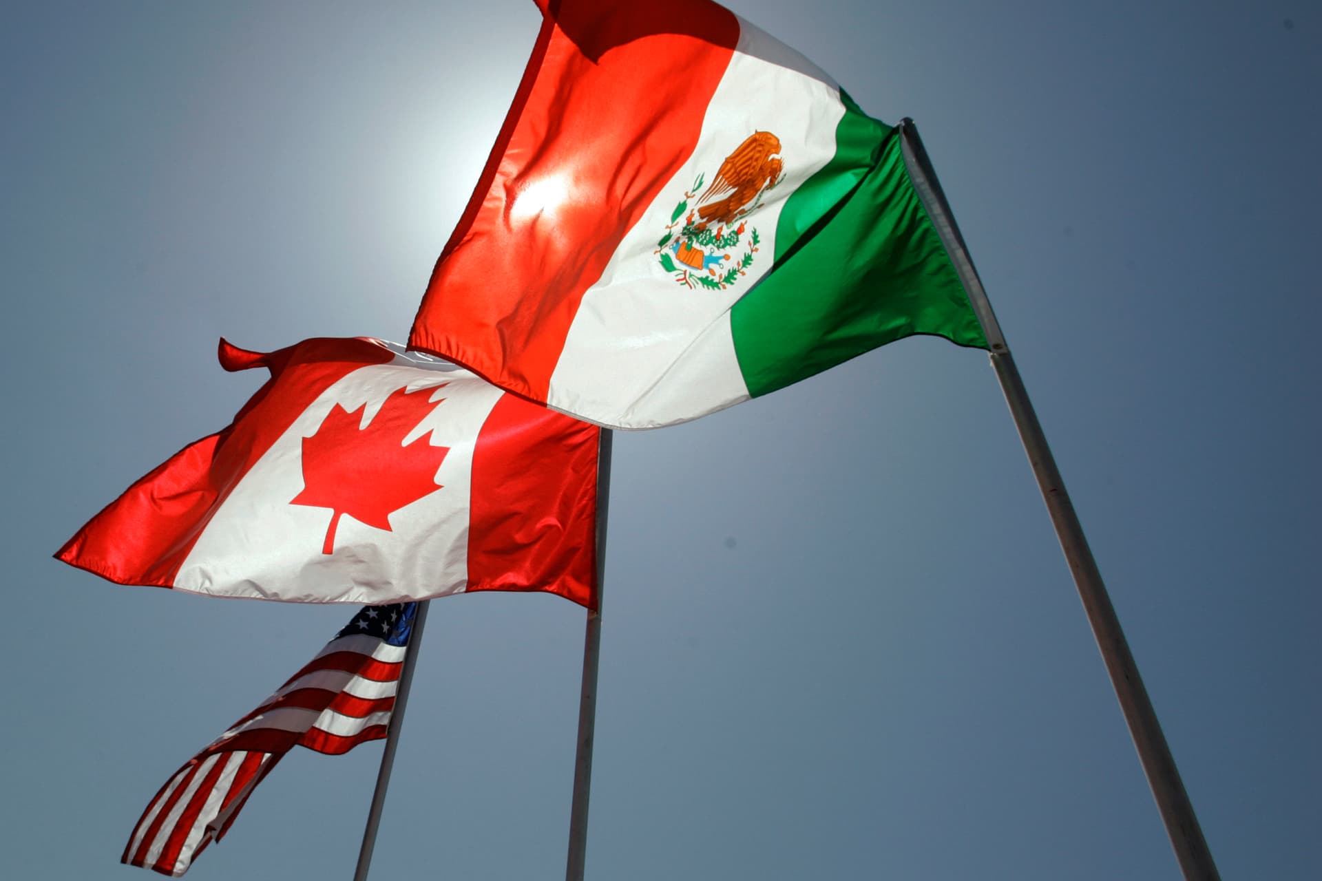 Flags representing the United States, Canada, and Mexico.