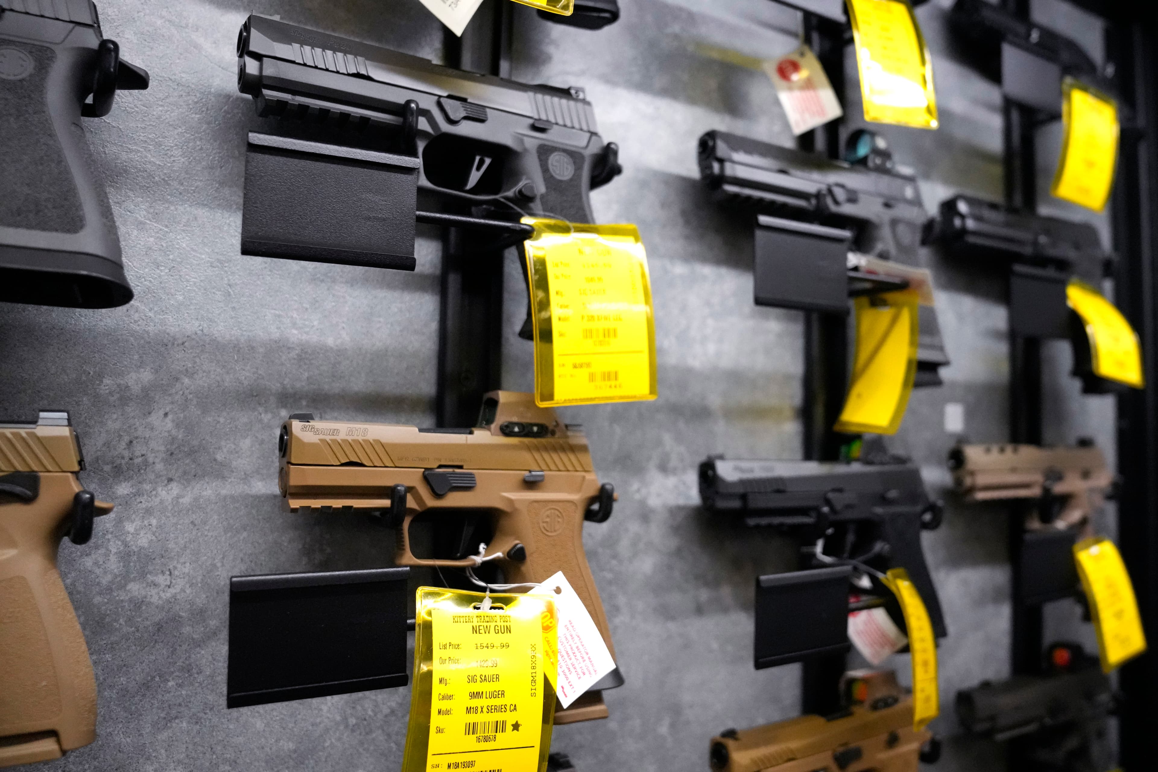 A selection of Sig Sauer pistols are displayed at a gun shop.