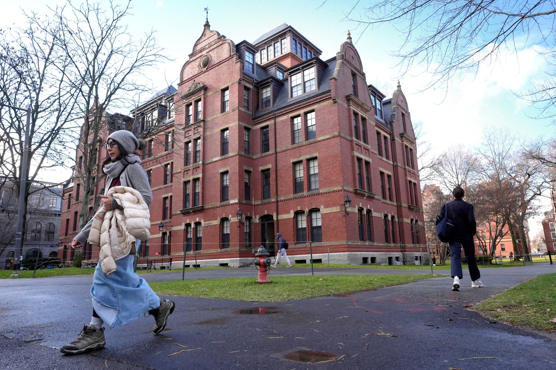 People walk between buildings on the campus of Harvard University.