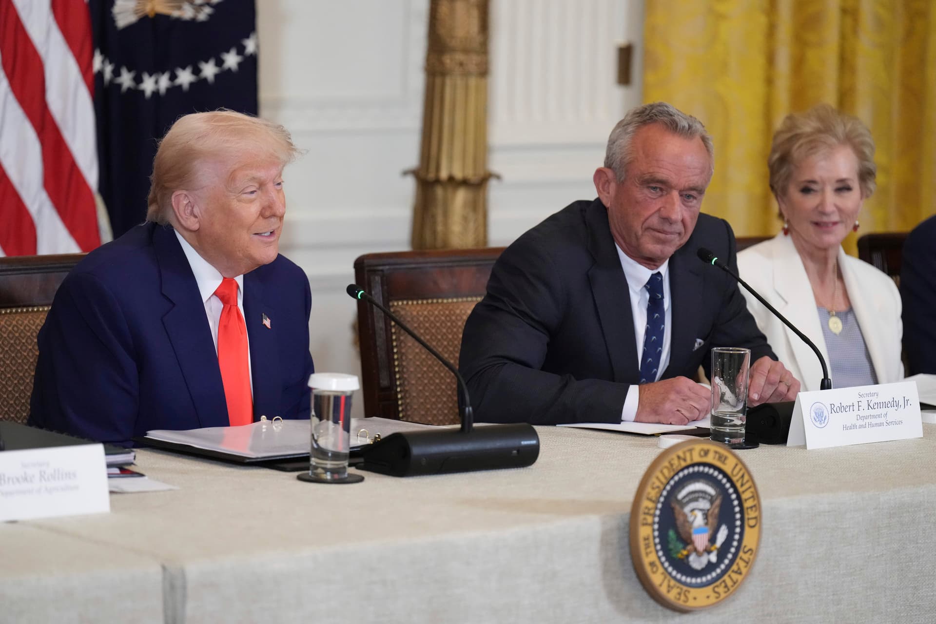 President Trump, left, speaks as Education Secretary Linda McMahon, right, and Health and Human Services Secretary Robert F. Kennedy Jr. listen at a Make America Healthy Again Commission Event.