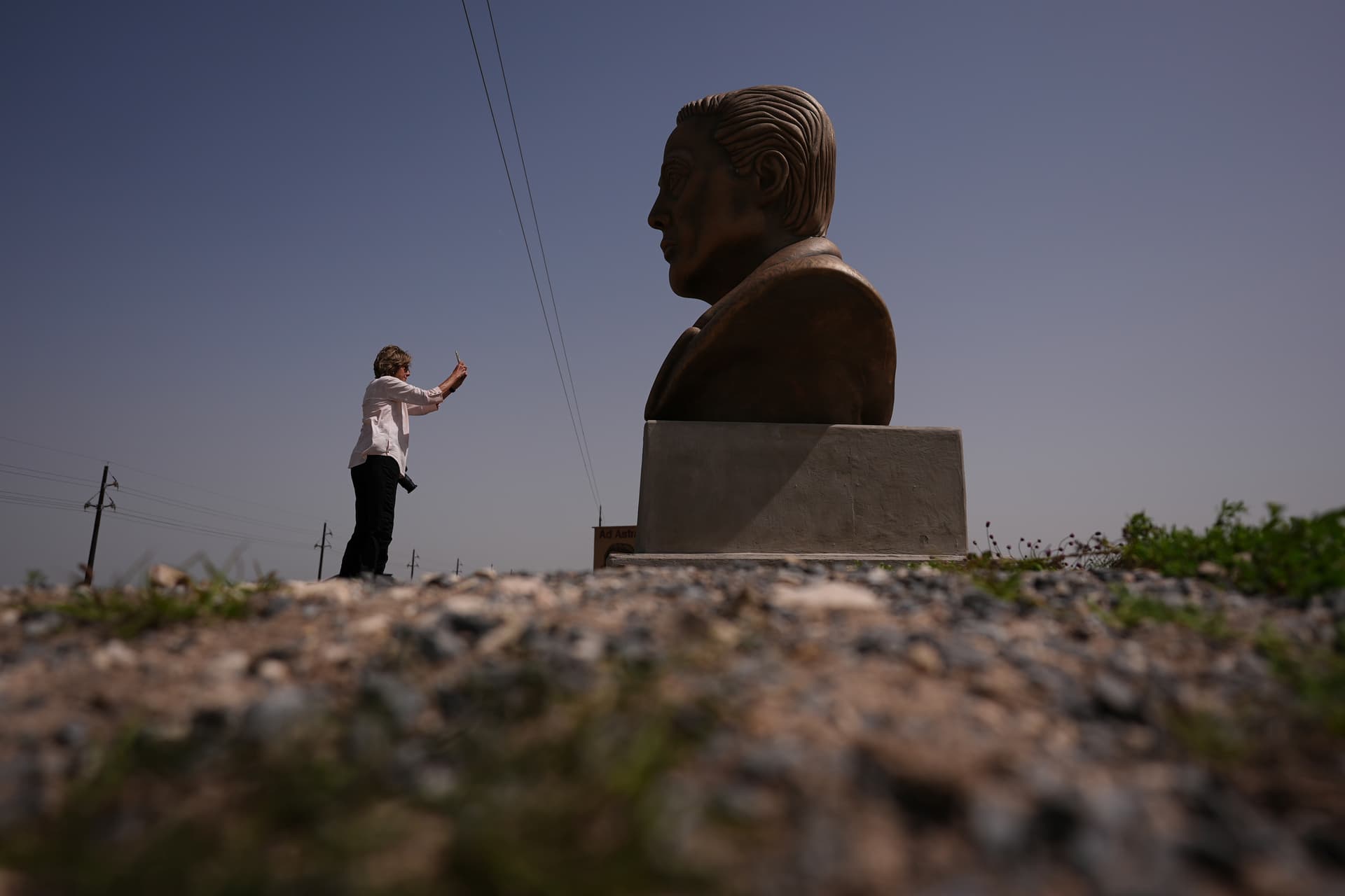 A visitor photographs a large bust of Elon Musk near SpaceX's Starbase in Boca Chica, Texas, March 5, 2025. 