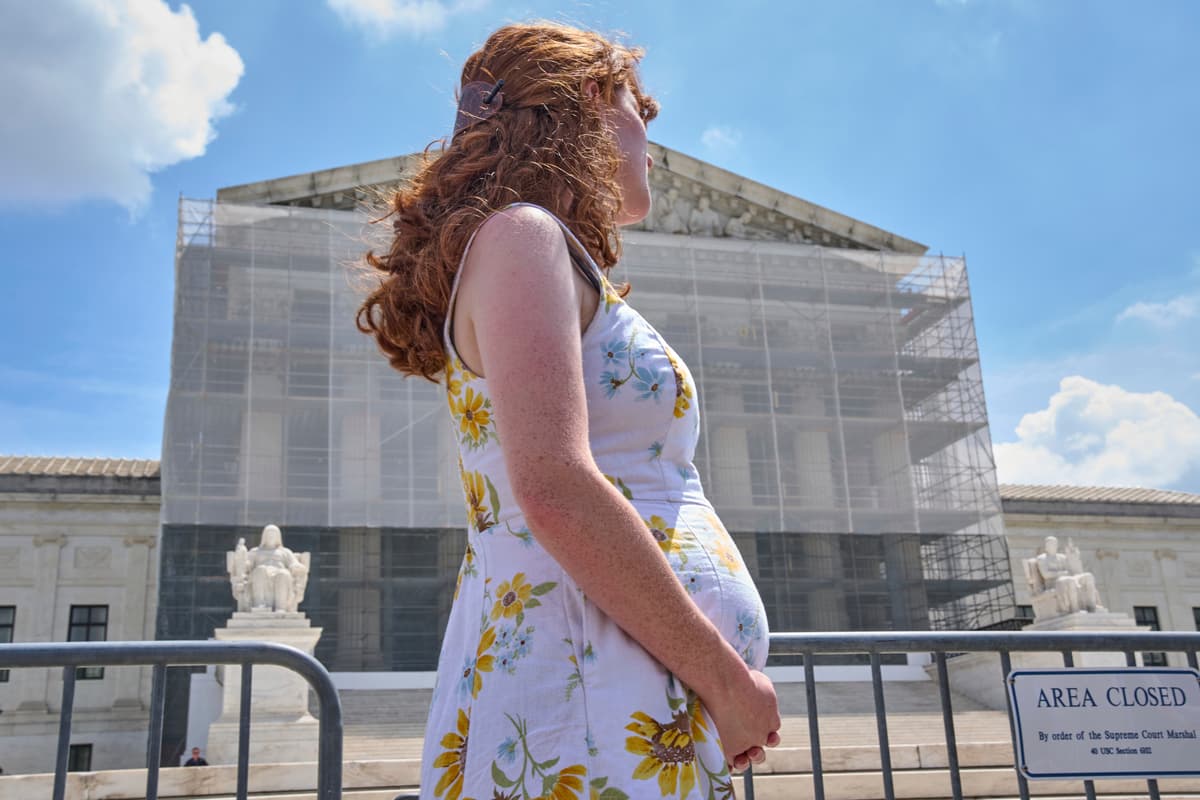 A pregnant American citizen, Mairelise Robinson, protests outside the Supreme Court on May 15, 2025.