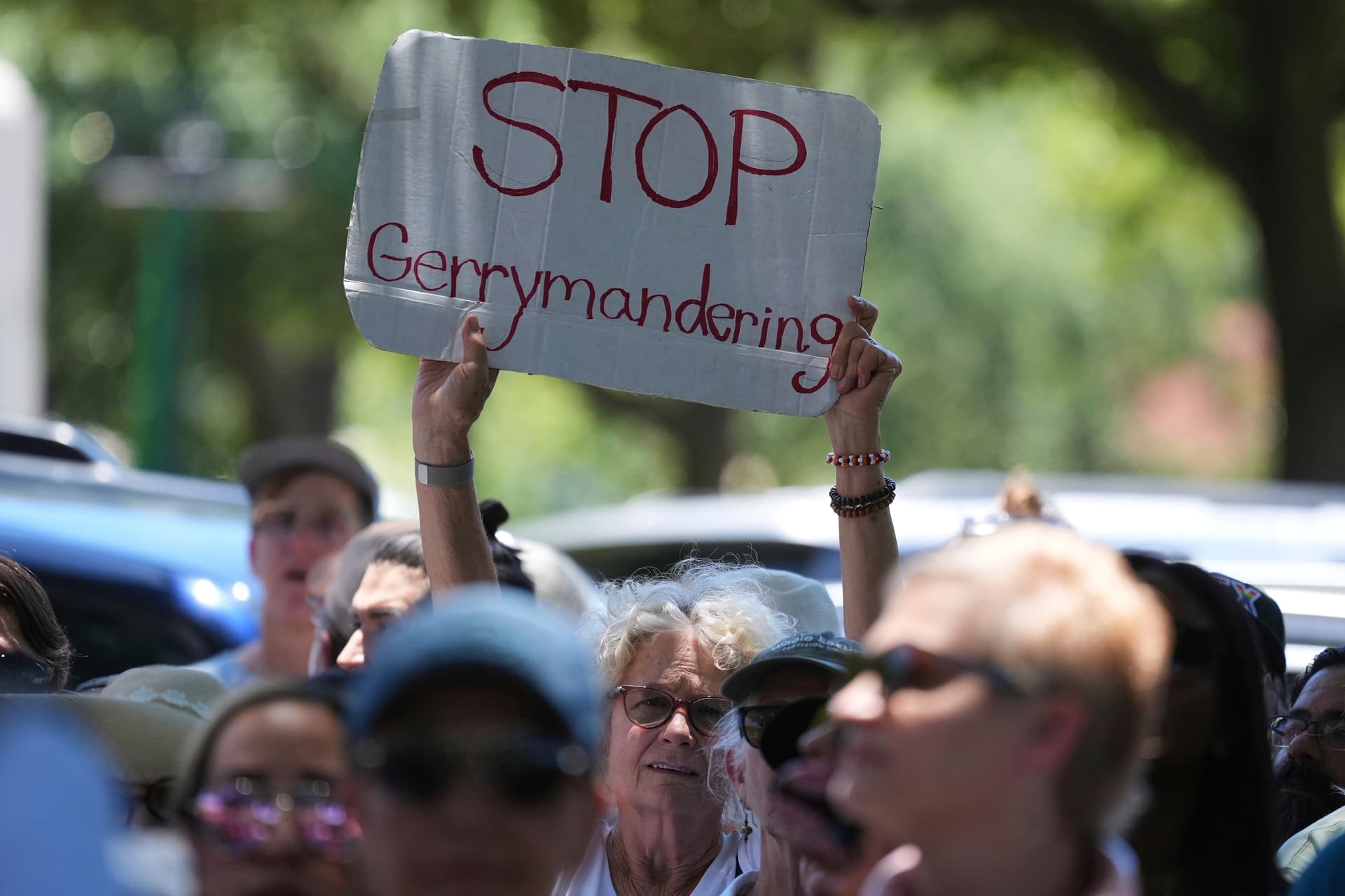 A woman holds a sign during a rally to protest against redistricting hearings at the Texas state Capitol.