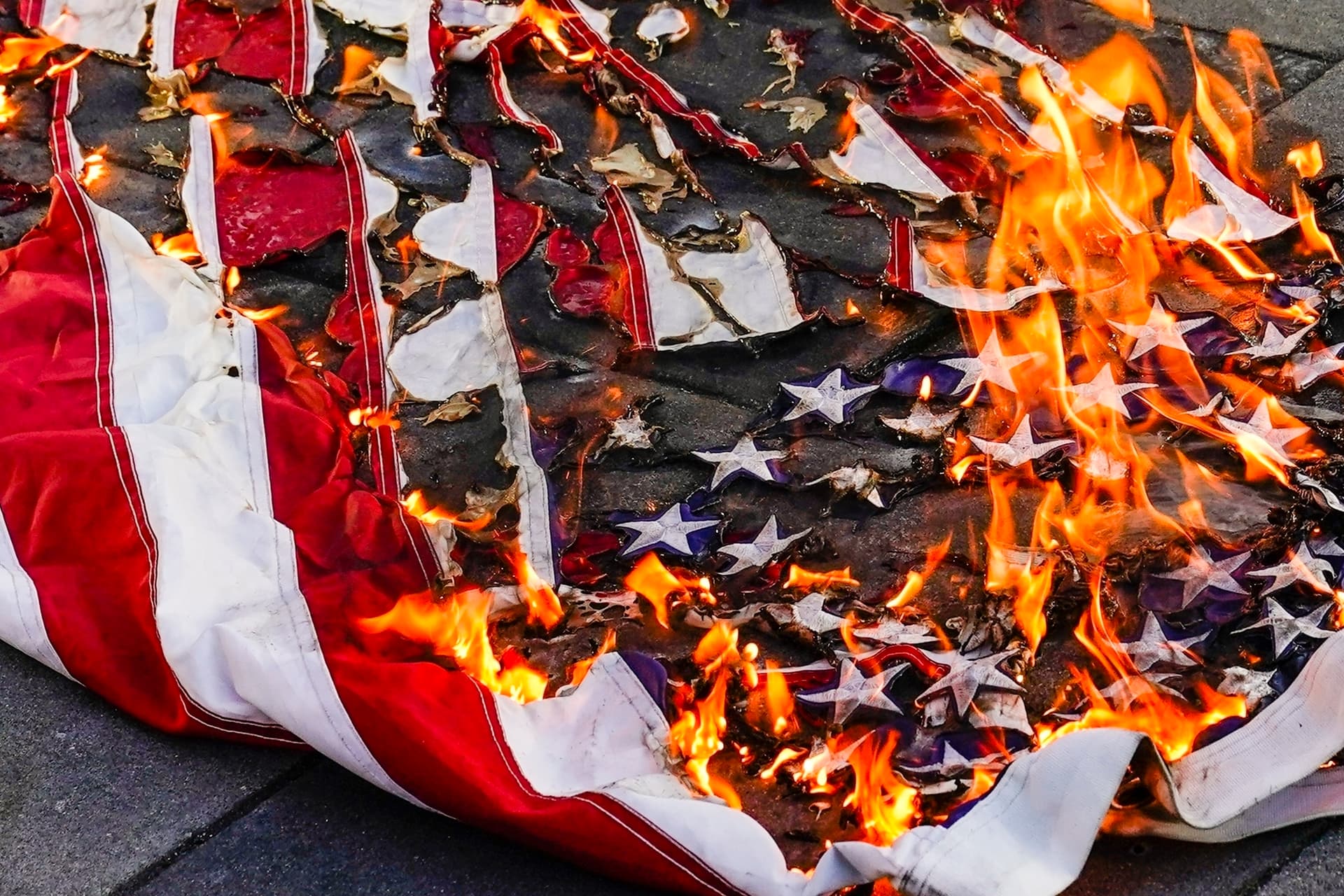 An American flag is burned during a march for Jayland Walker, July 6, 2022, at New York.
