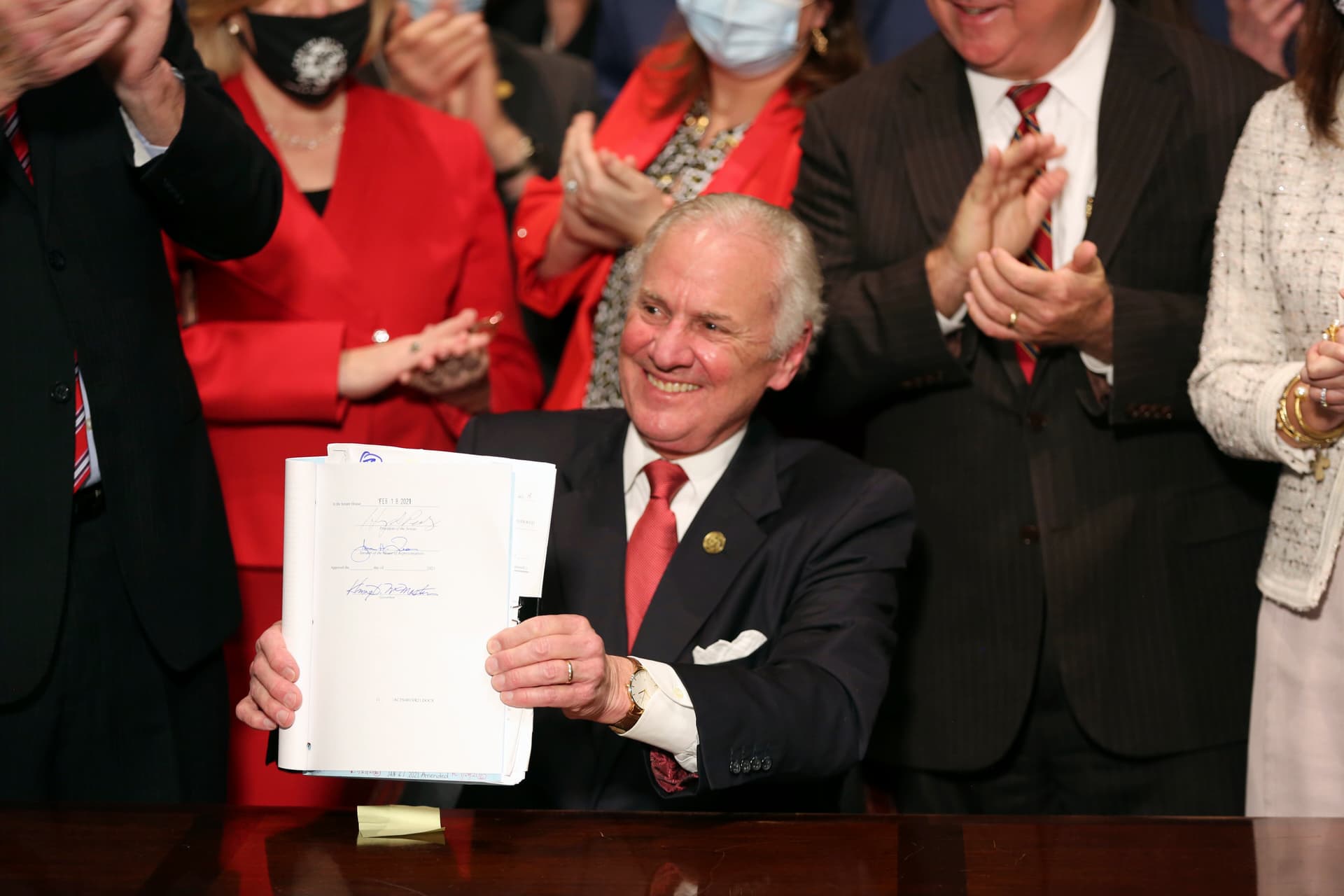 Governor Henry McMaster holds up a bill banning almost all abortions in South Carolina after he signed it into law on February 18, 2021, at Columbia.