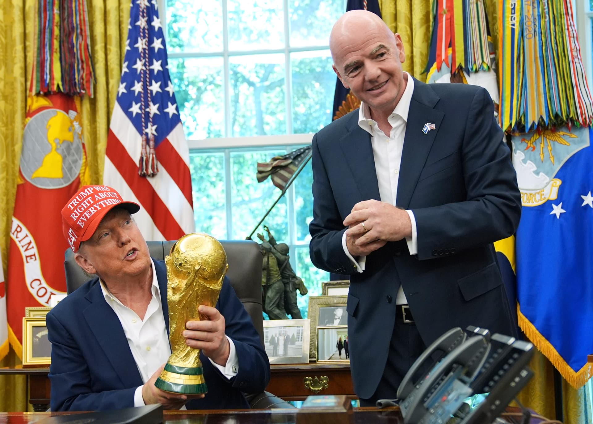 President Trump holds the FIFA World Cup Winners Trophy as the FIFA president, Gianni Infantino, looks on at the White House on August 22, 2025.