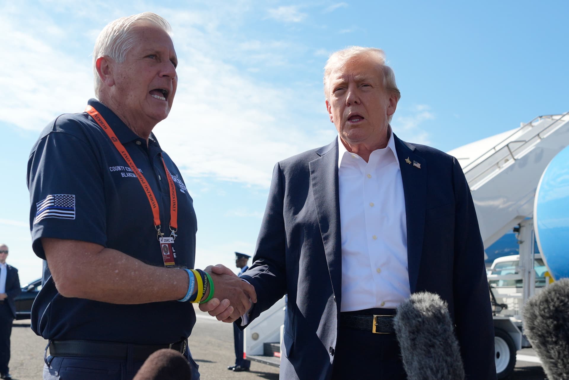 President Trump shakes the hand of Nassau County Executive Bruce Blakeman while speaking with reporters as Trump arrives on Air Force One at Republic Airport, September 26, 2025.