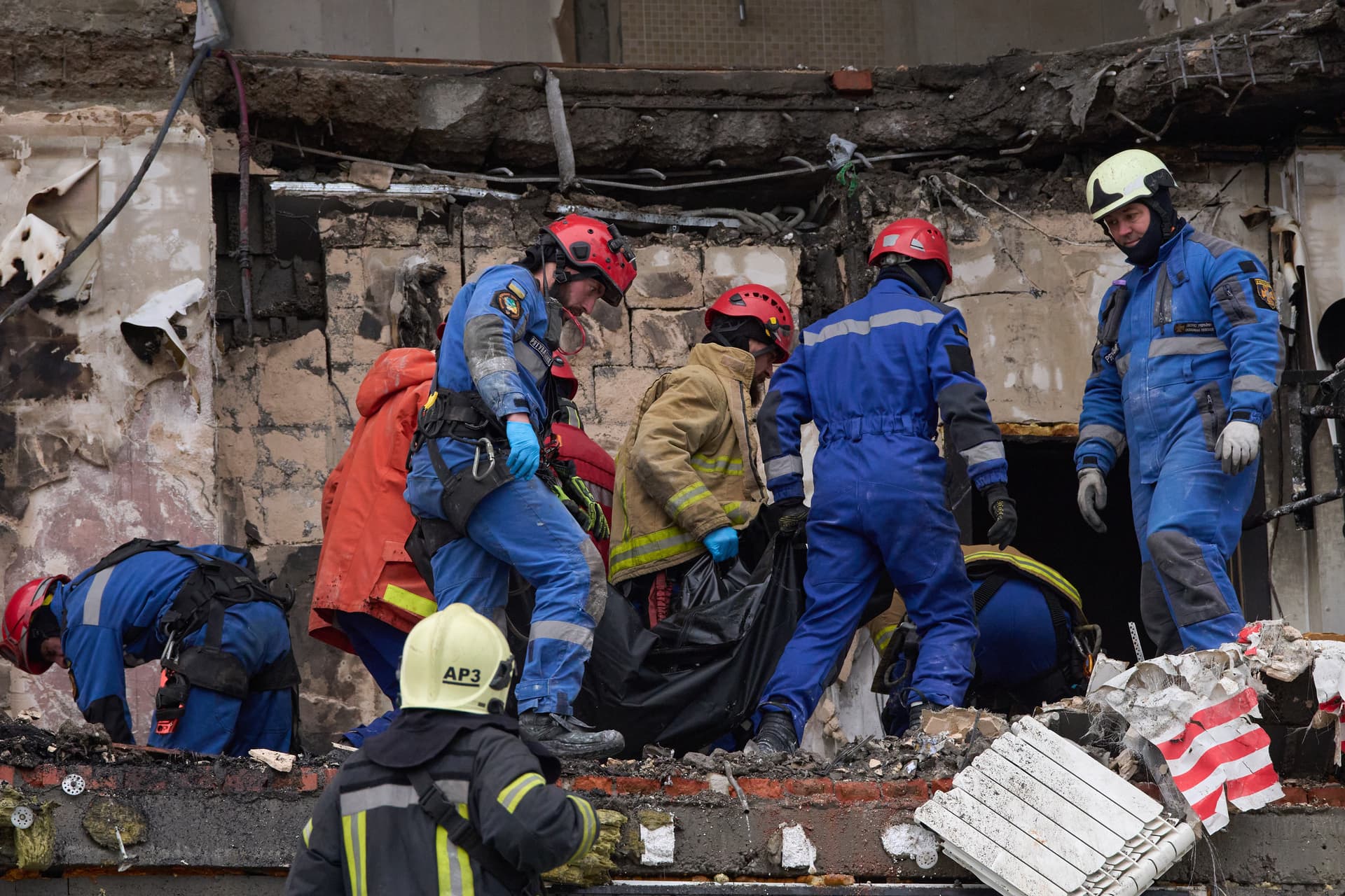 Rescuers carry the body of a victim after a Russian drone hit a apartment building during a massive missile and drone attack at Kyiv, Ukraine on December 27, 2025.