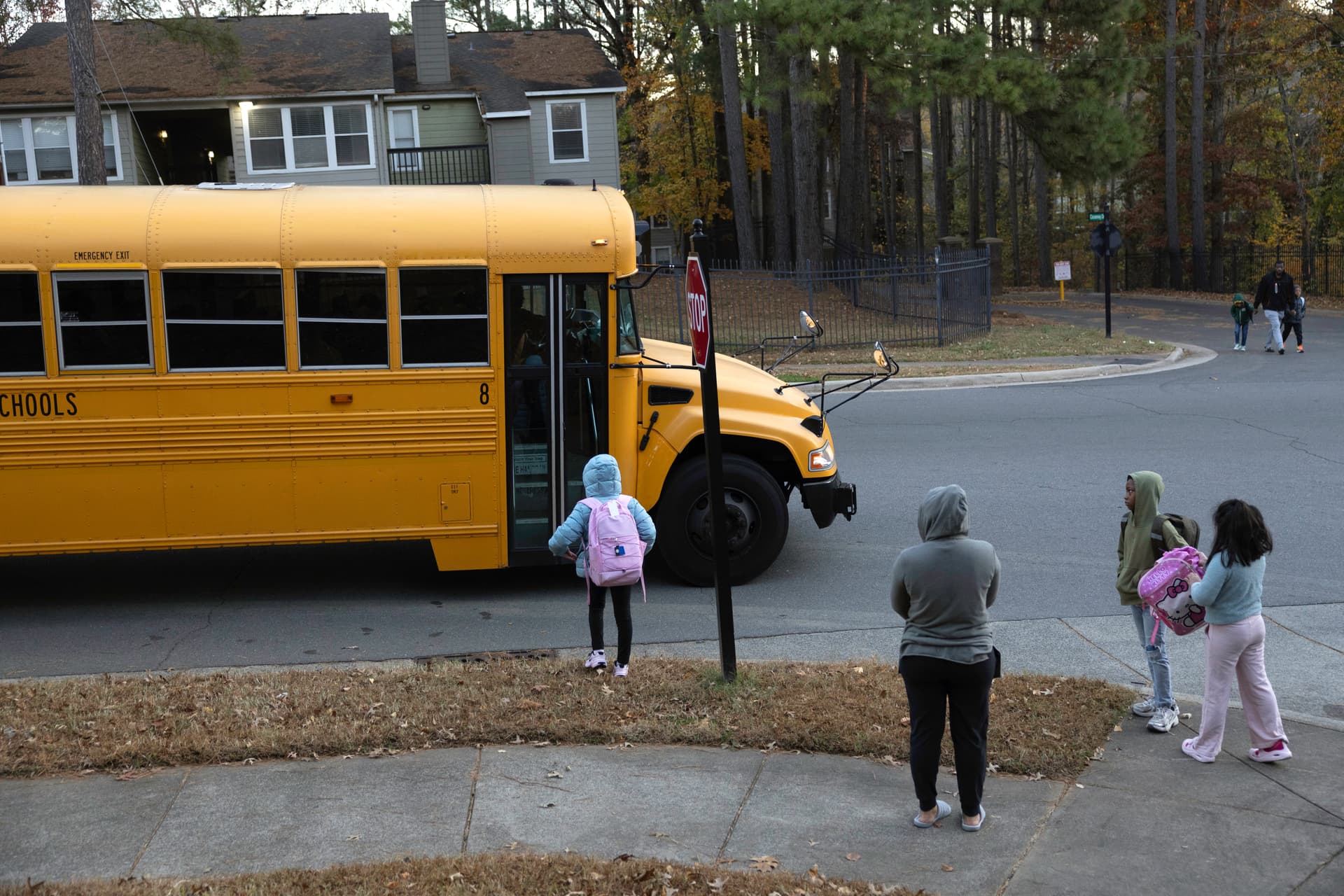 Students wait to board a school bus.