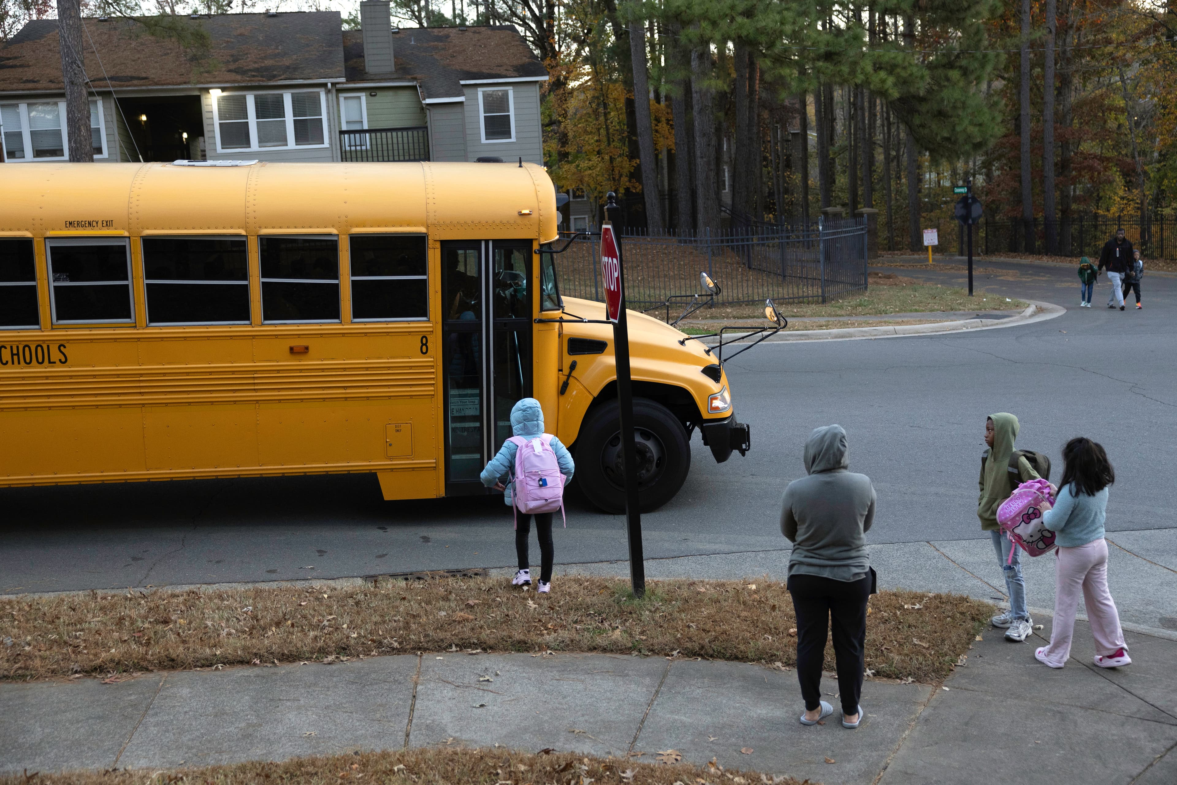 Students wait to board a school bus.