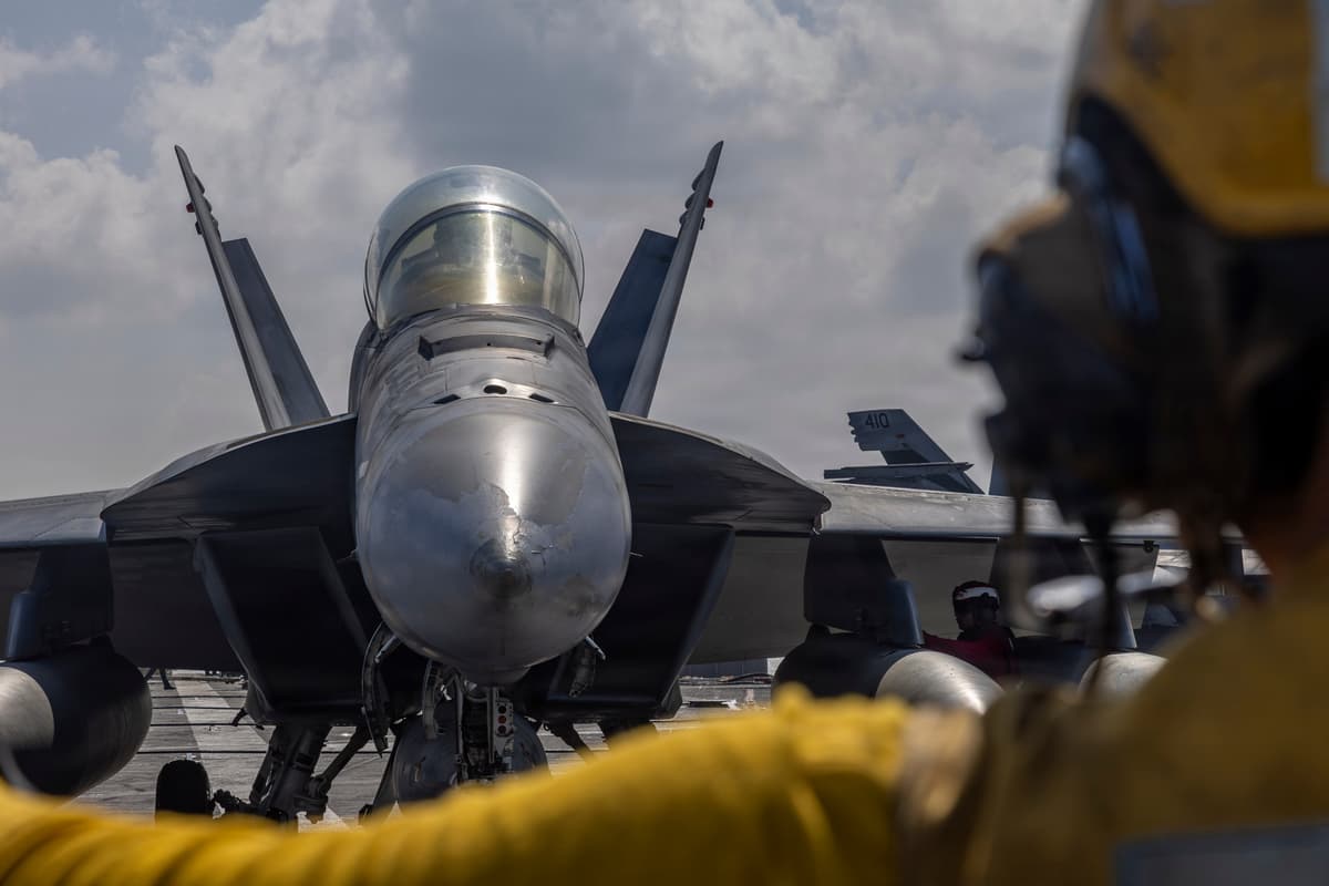 A U.S. Navy boatswain's mate directs an F/A-18F Super Hornet on the flight deck of the aircraft carrier USS Abraham Lincoln on January 23, 2026. 