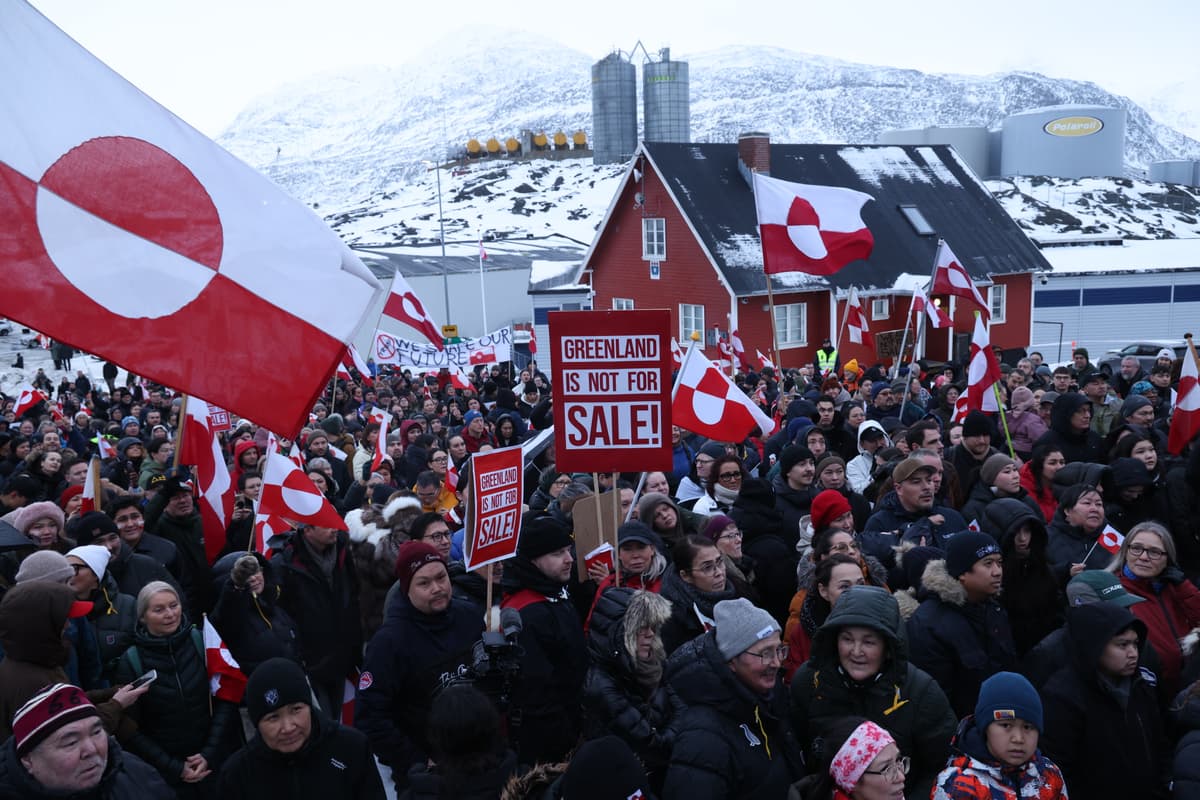 People hold Greenlandic flags and placards as they gather by the United States Consulate to march in protest against President Trump.