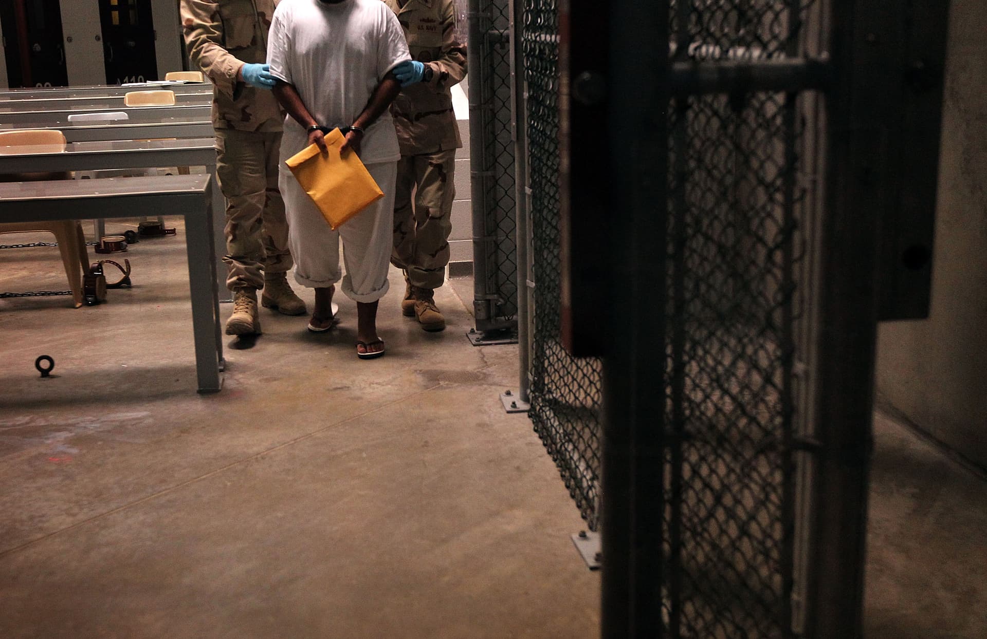 U.S. Navy guards escort a detainee after a 'life skills' class held for prisoners at Camp 6 in the Guantanamo Bay detention center on March 30, 2010 at Guantanamo Bay, Cuba.  