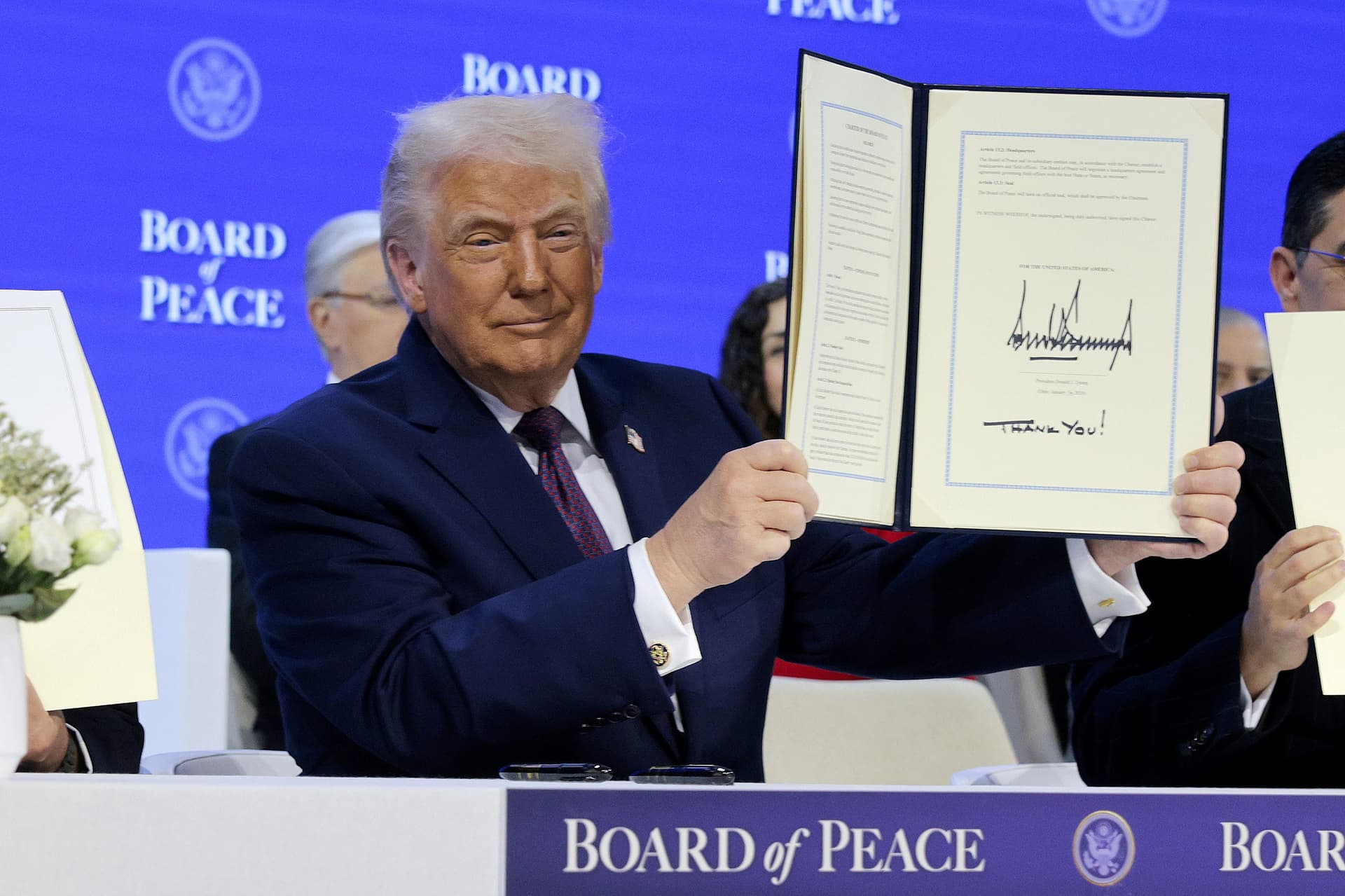 President Trump holds up his signature on the founding charter of the 'Board of Peace' at the World Economic Forum, January 22, 2026. 