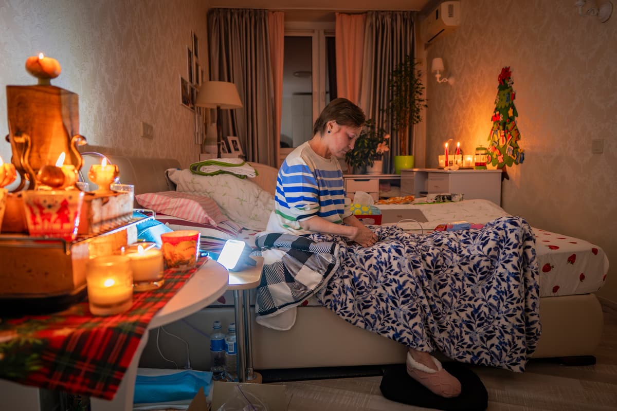 A Kyiv resident, Olena Janchuk, 53, who can no longer walk due to illness, endures a blackout after Russian attacks on Ukraine's energy infrastructure, January 20, 2026. 