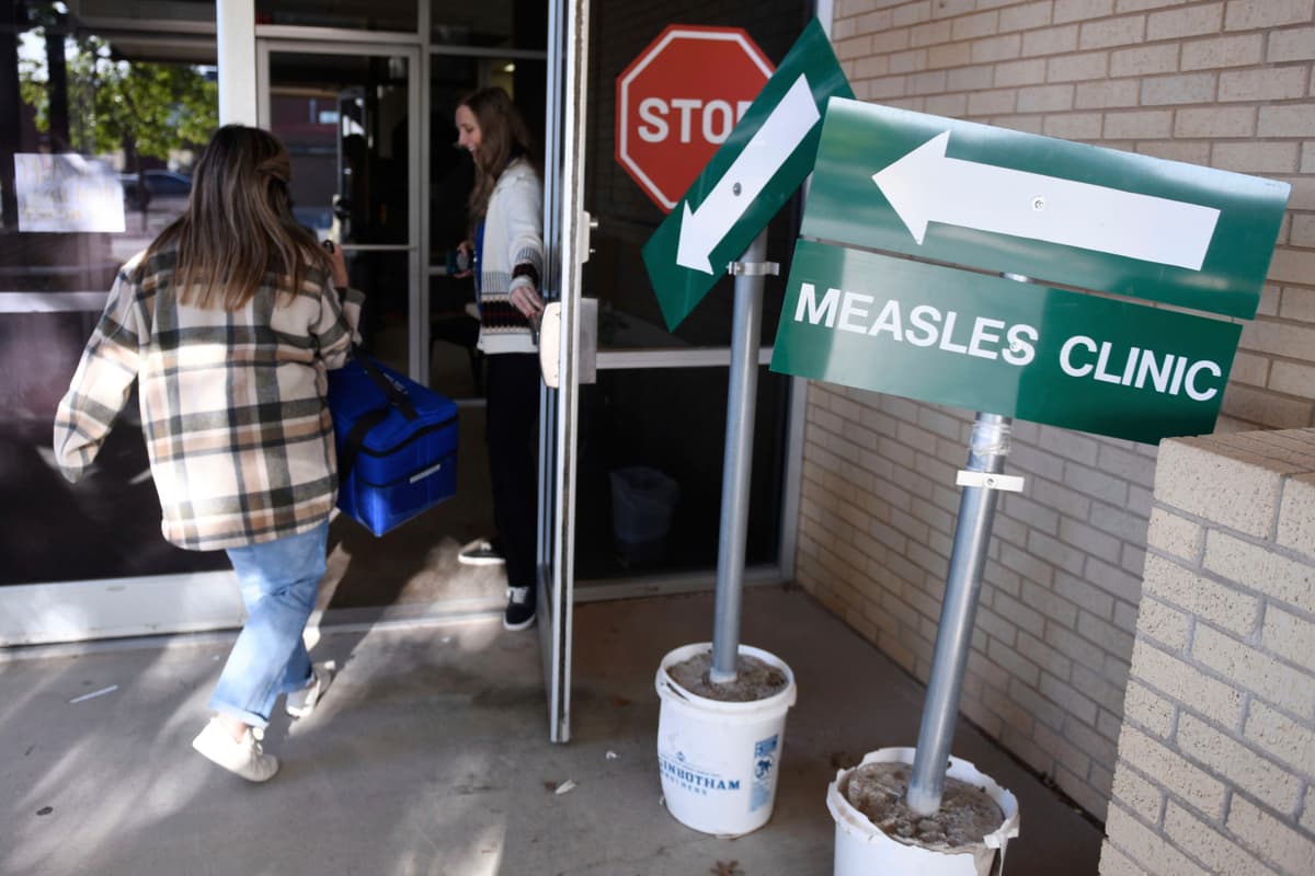 Health department staff members enter the Andrews County Health Department measles clinic carrying doses of the measles, mumps and rubella vaccine at Andrews, Texas.