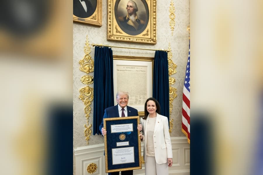 Trump poses with Venezuela's exiled politician María Corina Machado in the White House after she gave the president her Nobel Peace Prize medal during a visit to the White House.