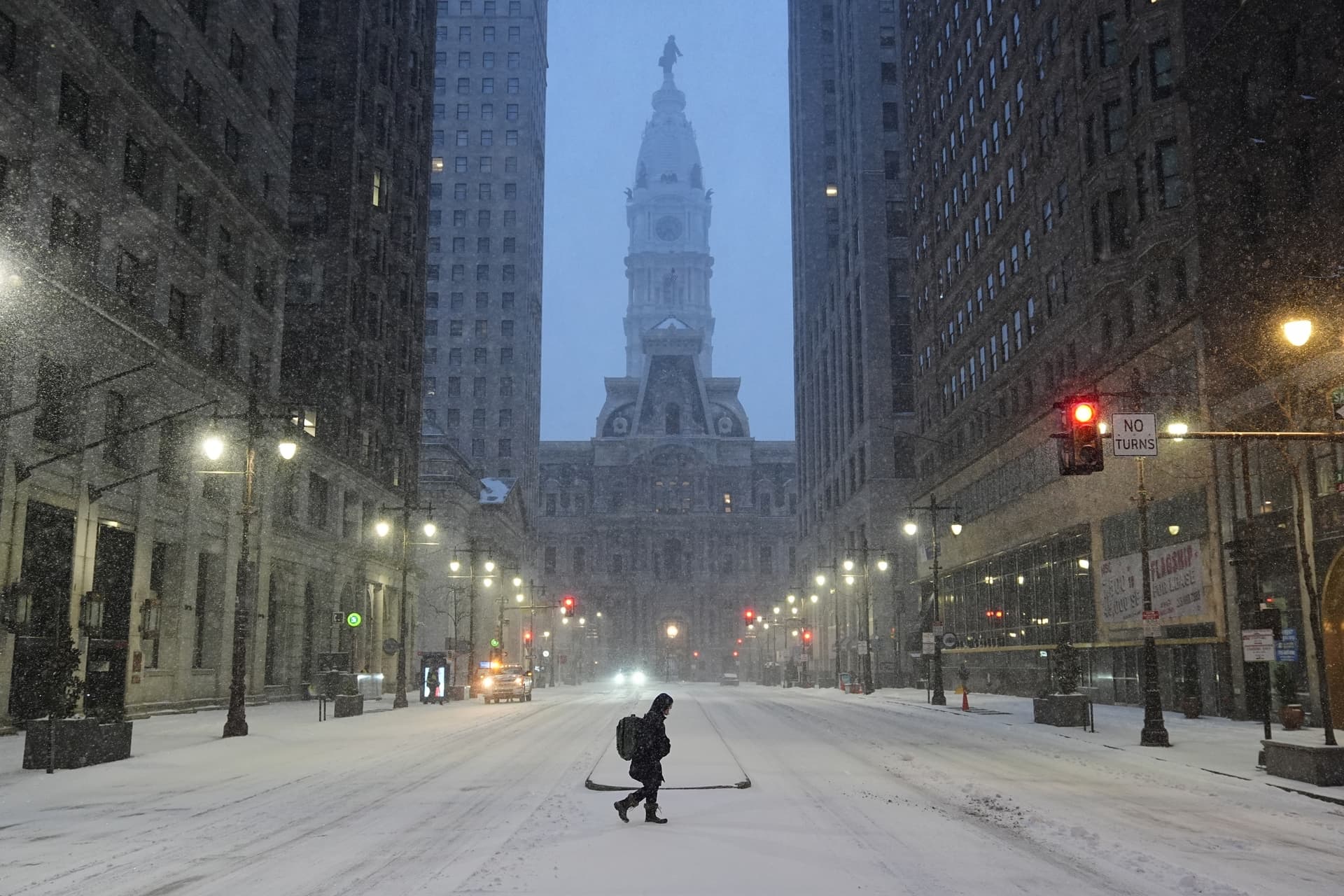 A person walks across a street during a winter storm in Philadelphia, Sunday, Jan. 25, 2026.
