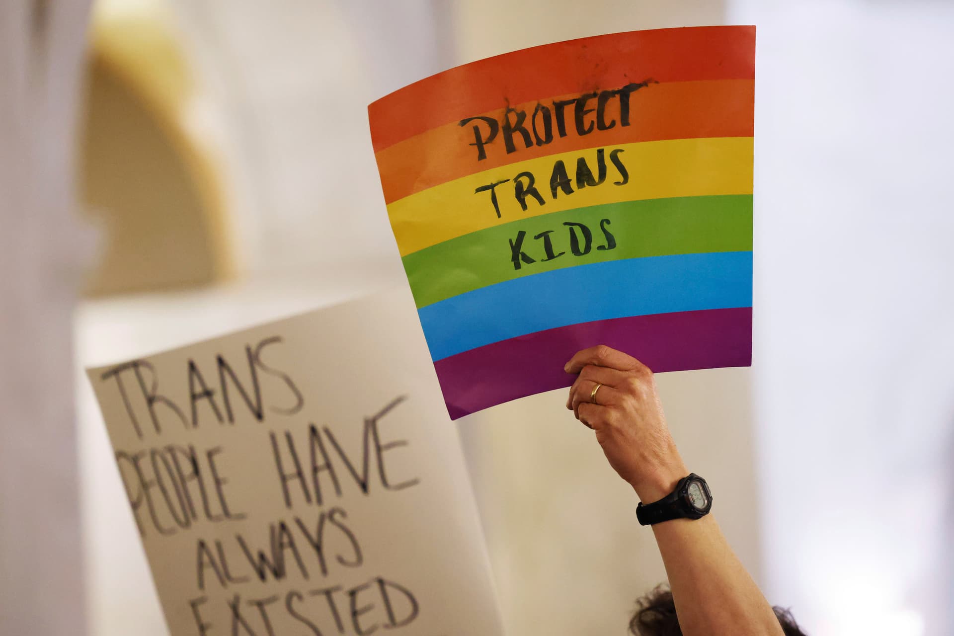 Protestors hold signs during a rally at the state capitol at Charleston, West Virginia, on March 9, 2023.  
