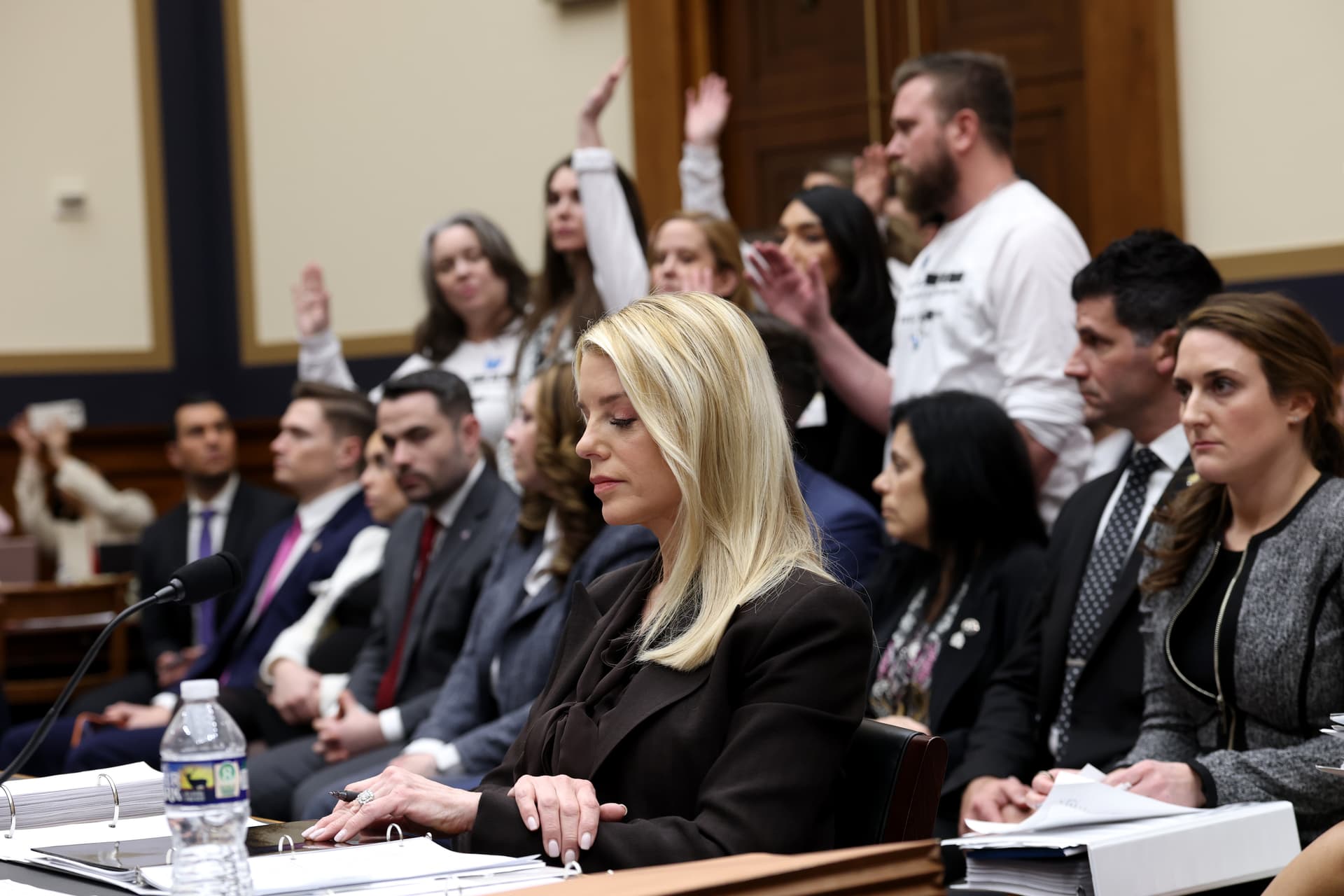 Survivors of convicted sex offender Jeffrey Epstein stand in the audience as U.S. Attorney General Pam Bondi testifies before the House Judiciary Committee on February 11, 2026, at Washington, DC. 