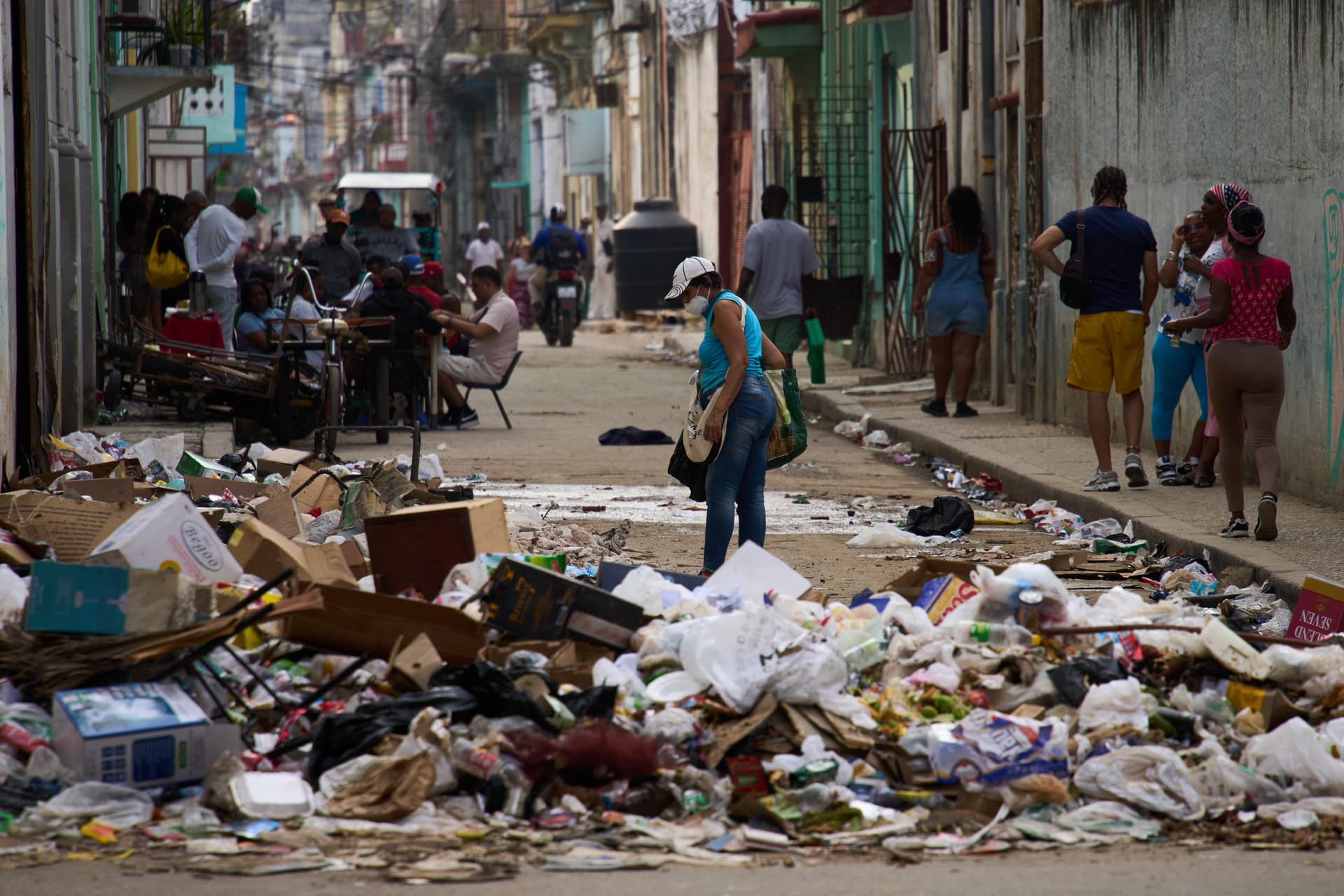 Pedestrians walk past trash at Havana, February 17, 2026. 