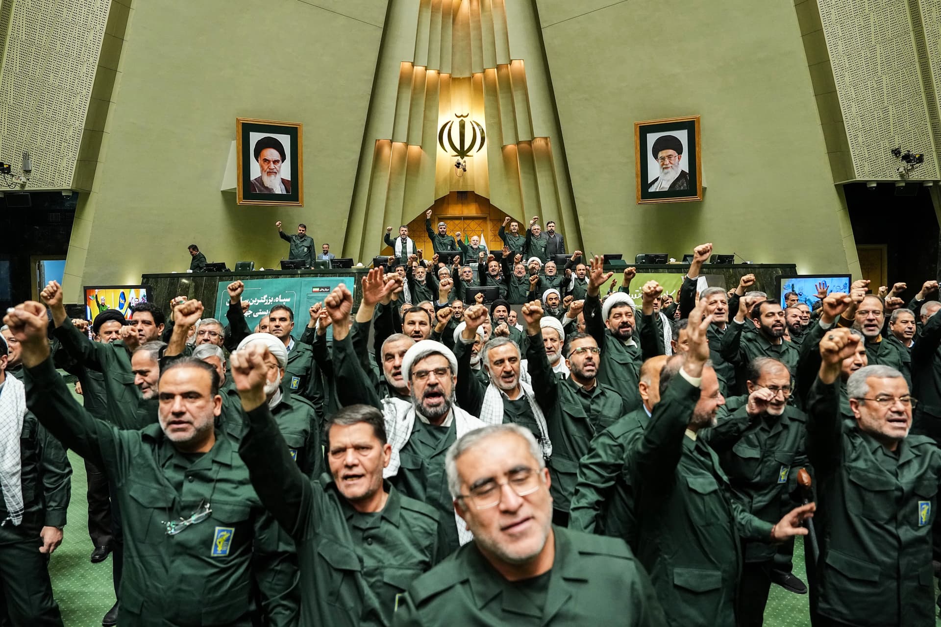 In this handout photo released by the Islamic Consultative Assembly News Agency (ICANA) Iranian lawmakers chant slogans as they wear the Revolutionary Guard's uniform in a session of parliament, at Tehran, Iran, Feb. 1, 2026. 