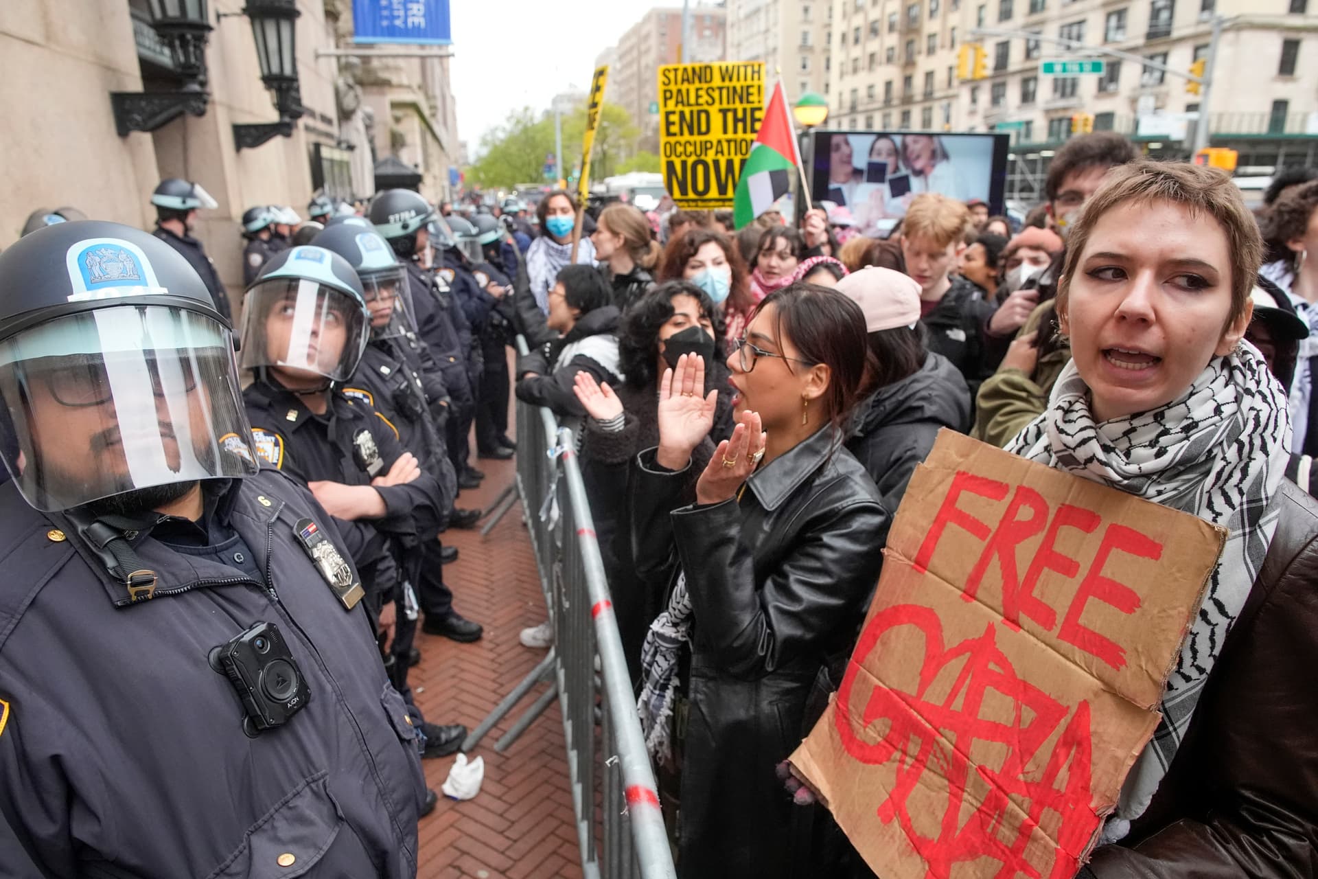 Police in Riot gear stand guard as demonstrators chant slogans outside the Columbia University campus, on April 18, 2024, in New York. 