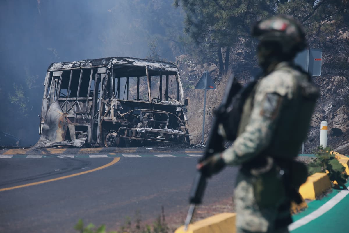 A soldier stands guard by a charred vehicle after it was set on fire, at Cointzio, Michoacán state, Mexico, February 22, 2026, following the death of the leader of the Jalisco New Generation Cartel, Nemesio Oseguera, known as "El Mencho." 