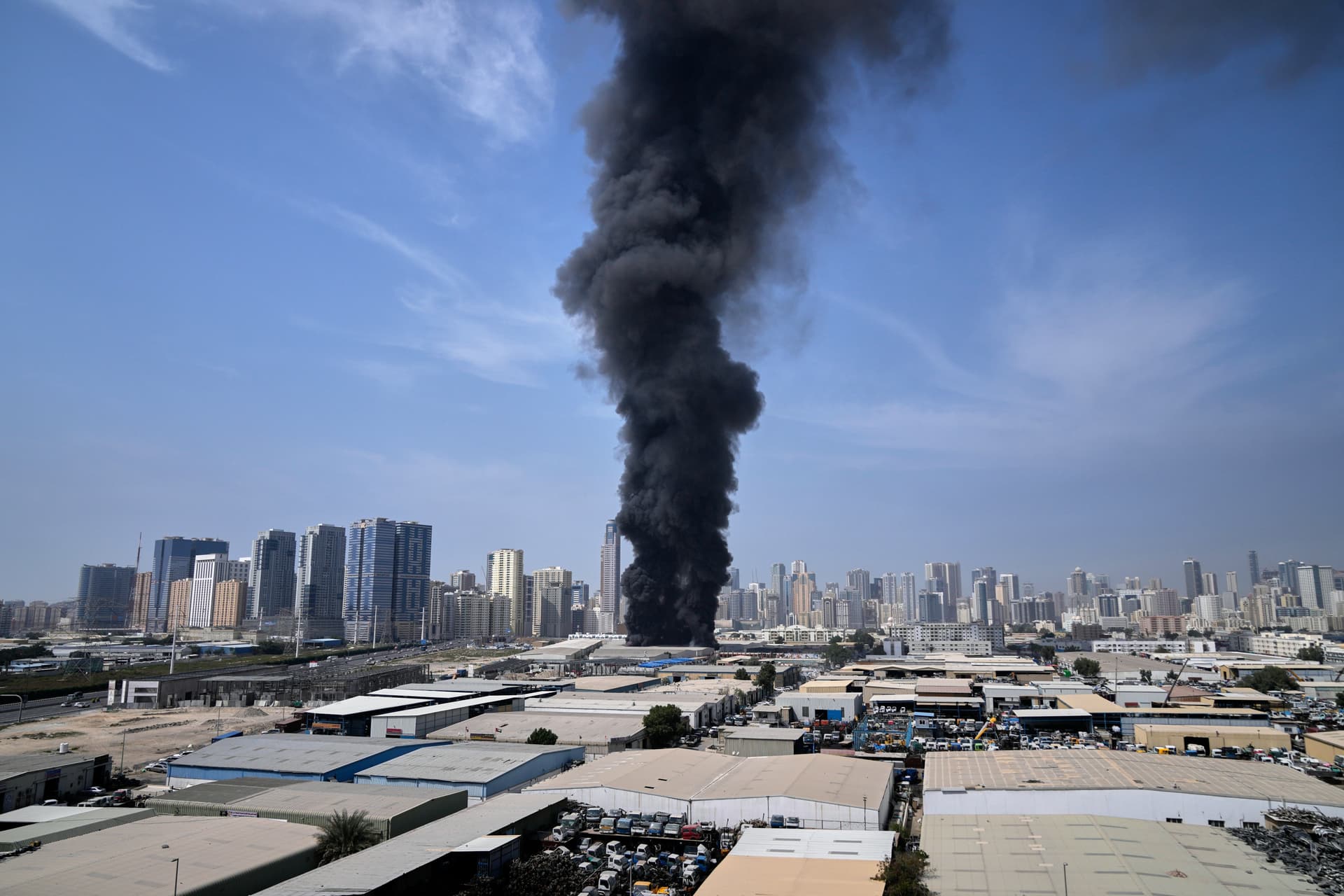 A black plume of smoke rises from a warehouse at the industrial area of Sharjah City in the United Arab Emirates following reports of Iranian strikes in Dubai, March 1, 2026. 