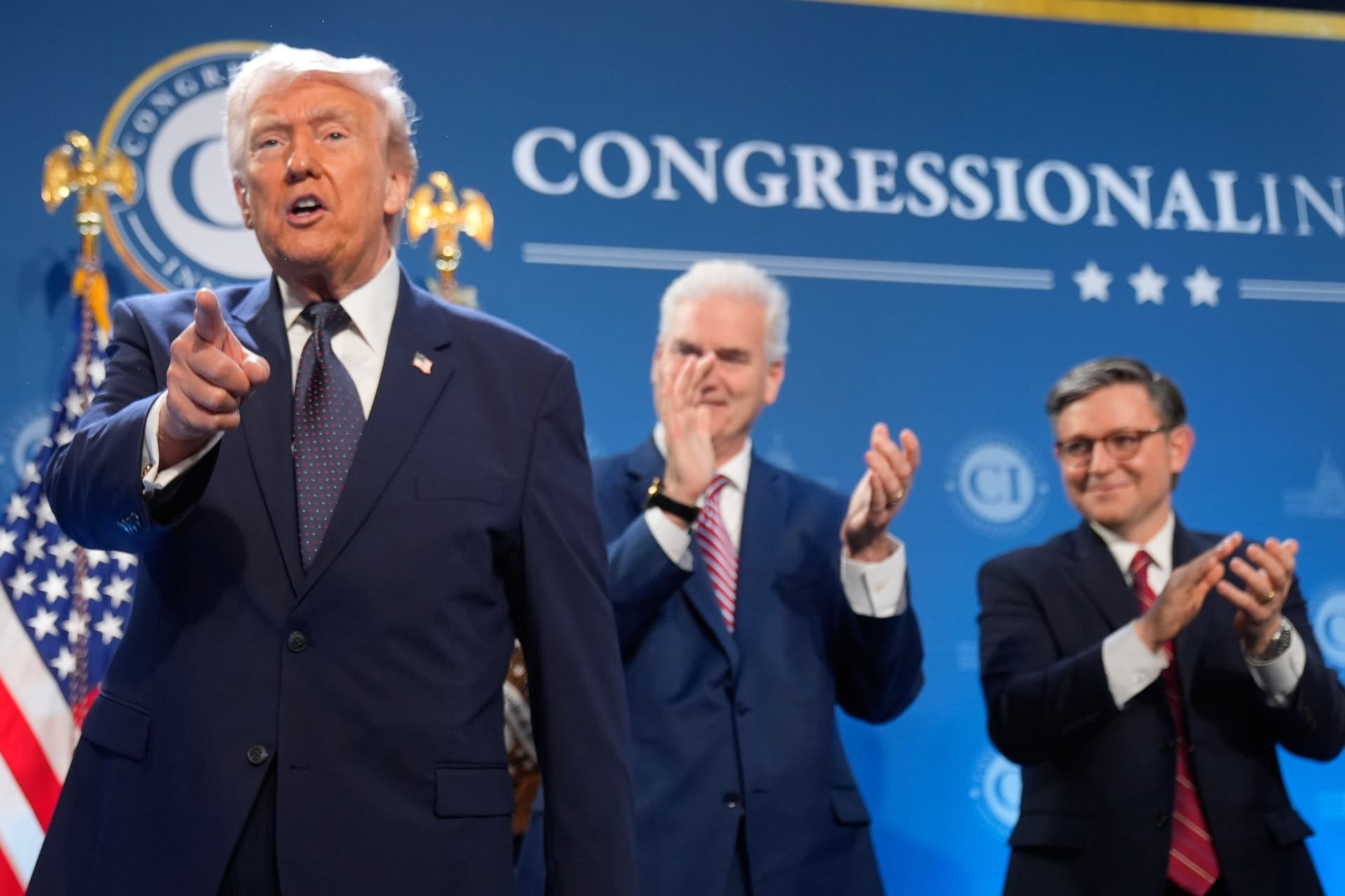 President Trump gestures as Representative Tom Emmer and House Speaker Mike Johnson applaud during the Republican Members Issues Conference, Monday, March 9, 2026, at Trump National Doral Miami in Doral, Florida.