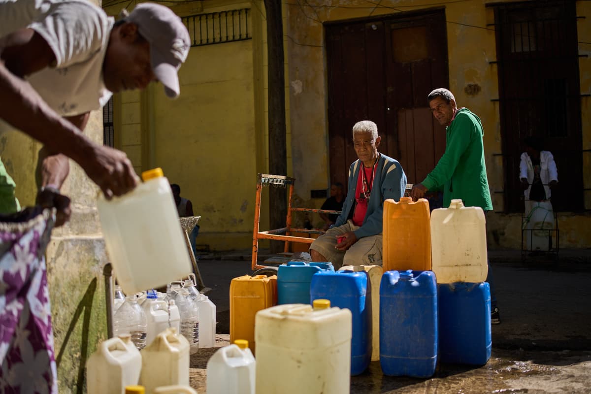 A man fills containers with potable water during a blackout at Havana on March 22, 2026.