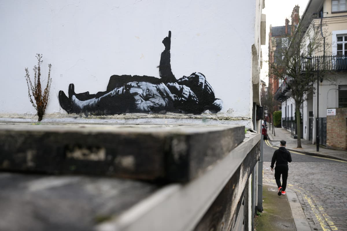 A man walks beneath a new Banksy artwork at London, England, on December 22, 2025.