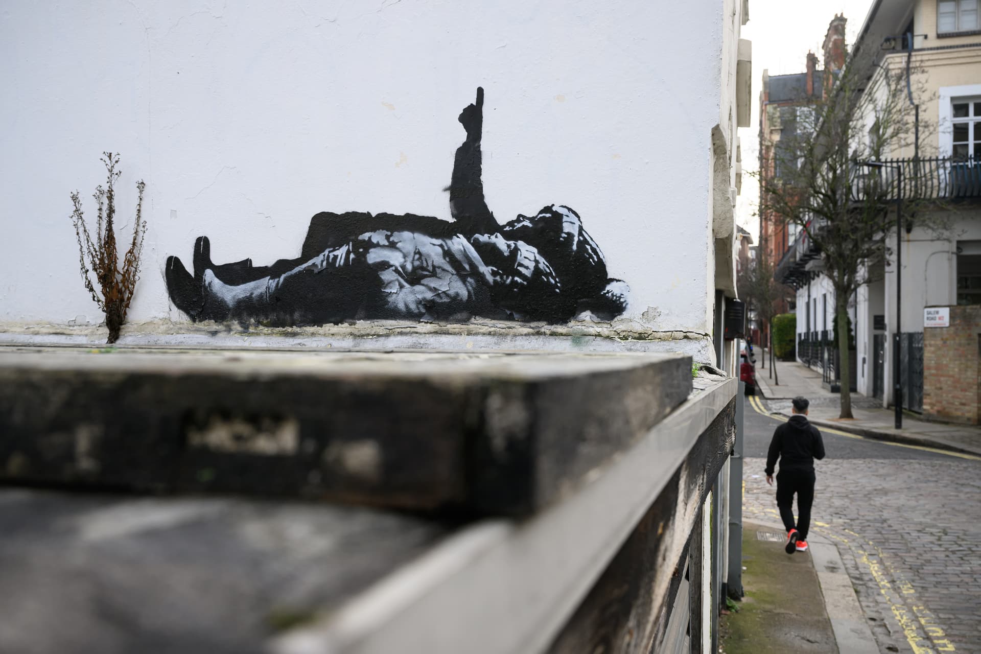 A man walks beneath a new Banksy artwork at London, England, on December 22, 2025.
