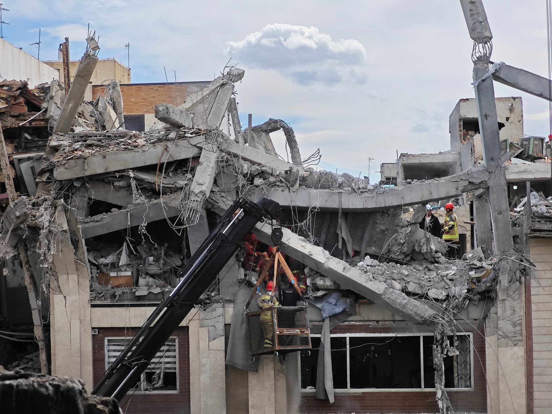 Rescue workers search for bodies in the rubble of a residential building following a hit in an airstrike in the early hours of March 27, 2026, at Tehran. 
